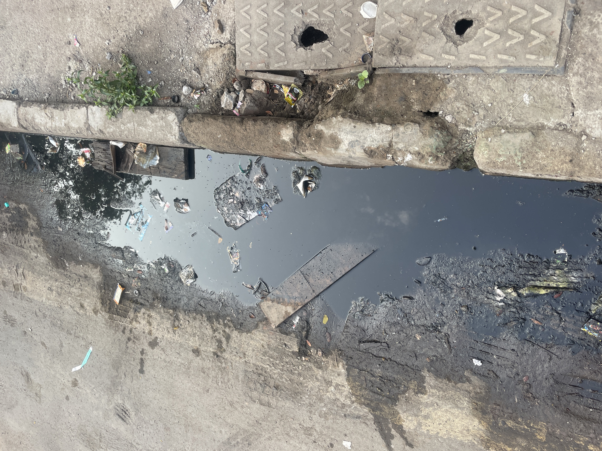 Urban scenes documented in Mumbai: drainage ditch, parked bus