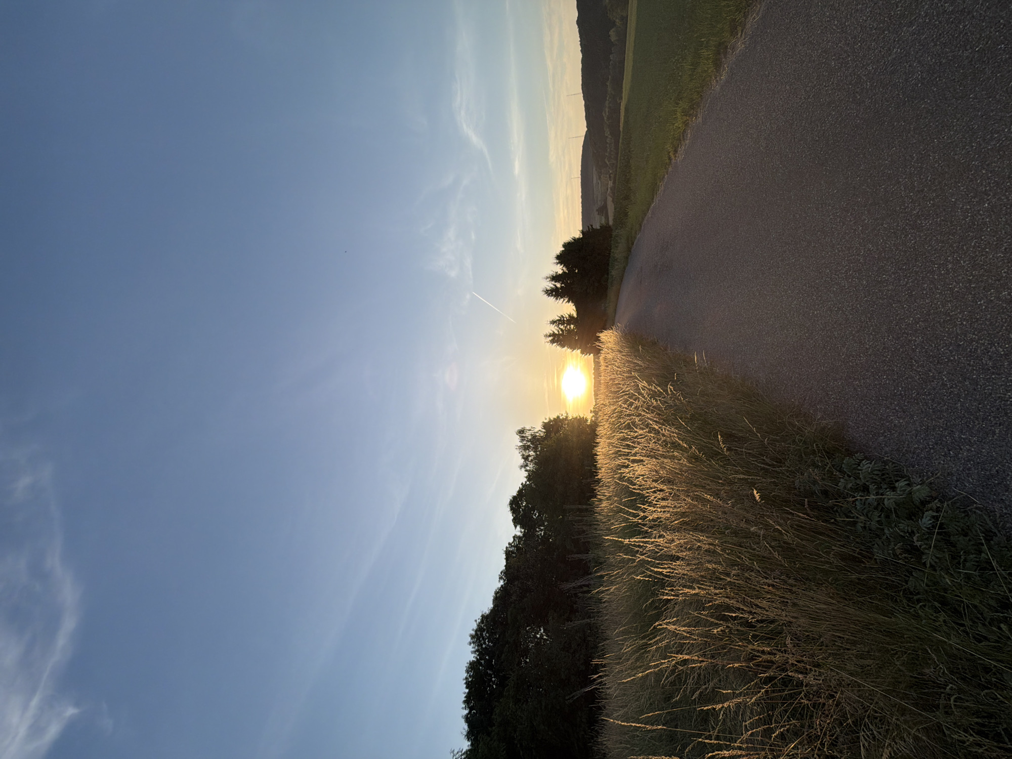 Summer solstice sunset along a quiet rural road in Luxembourg