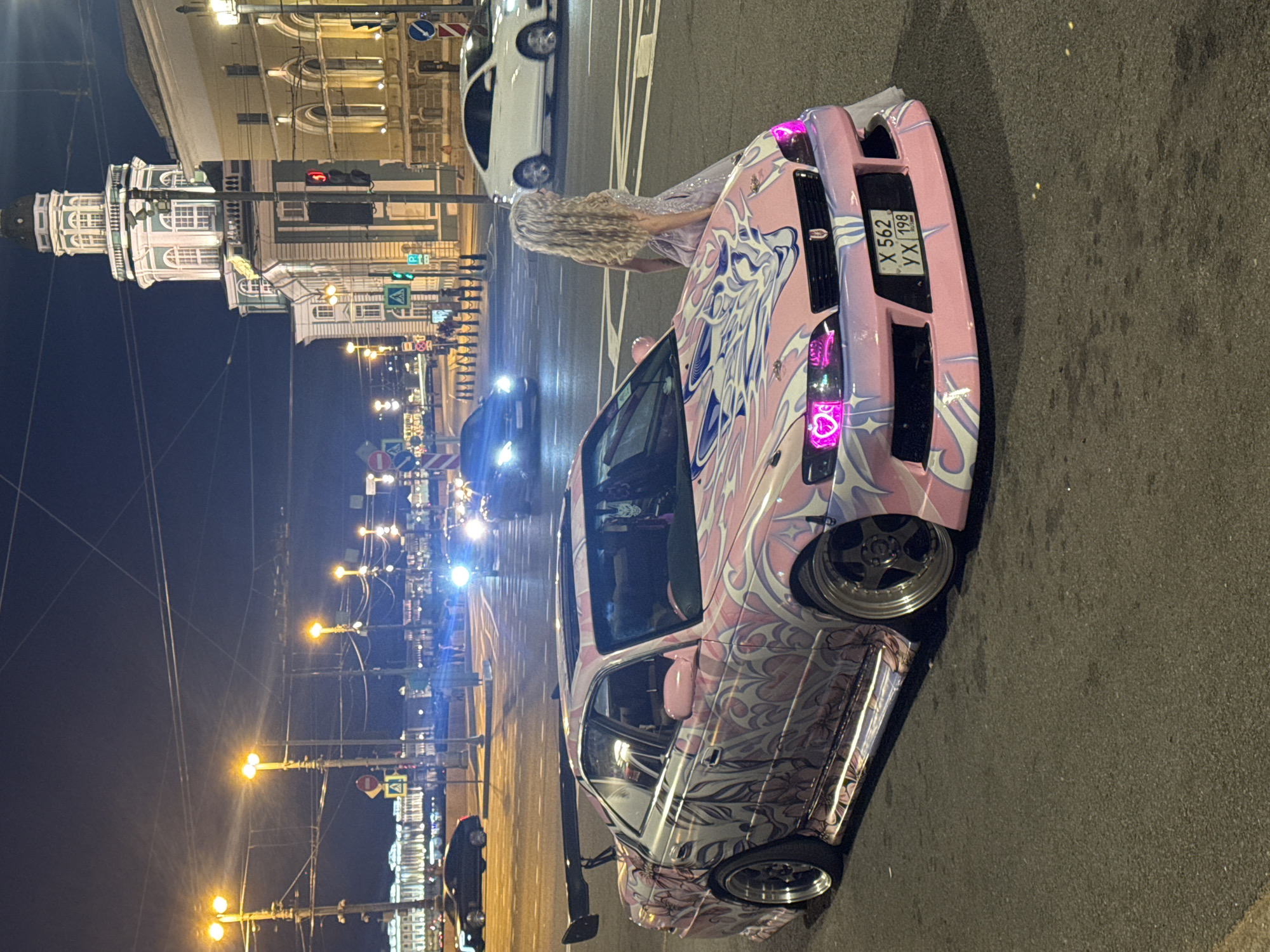 Anime-wrapped pink modified sedan parked on a Saint Petersburg street