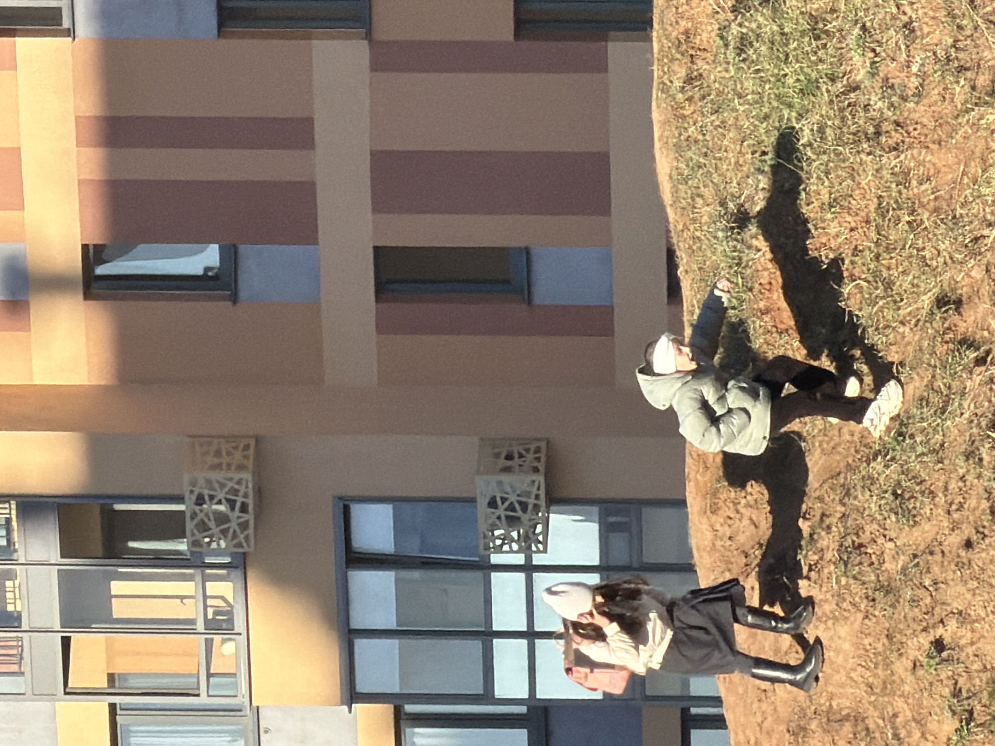 Two people stand near modern building in Izhevsk
