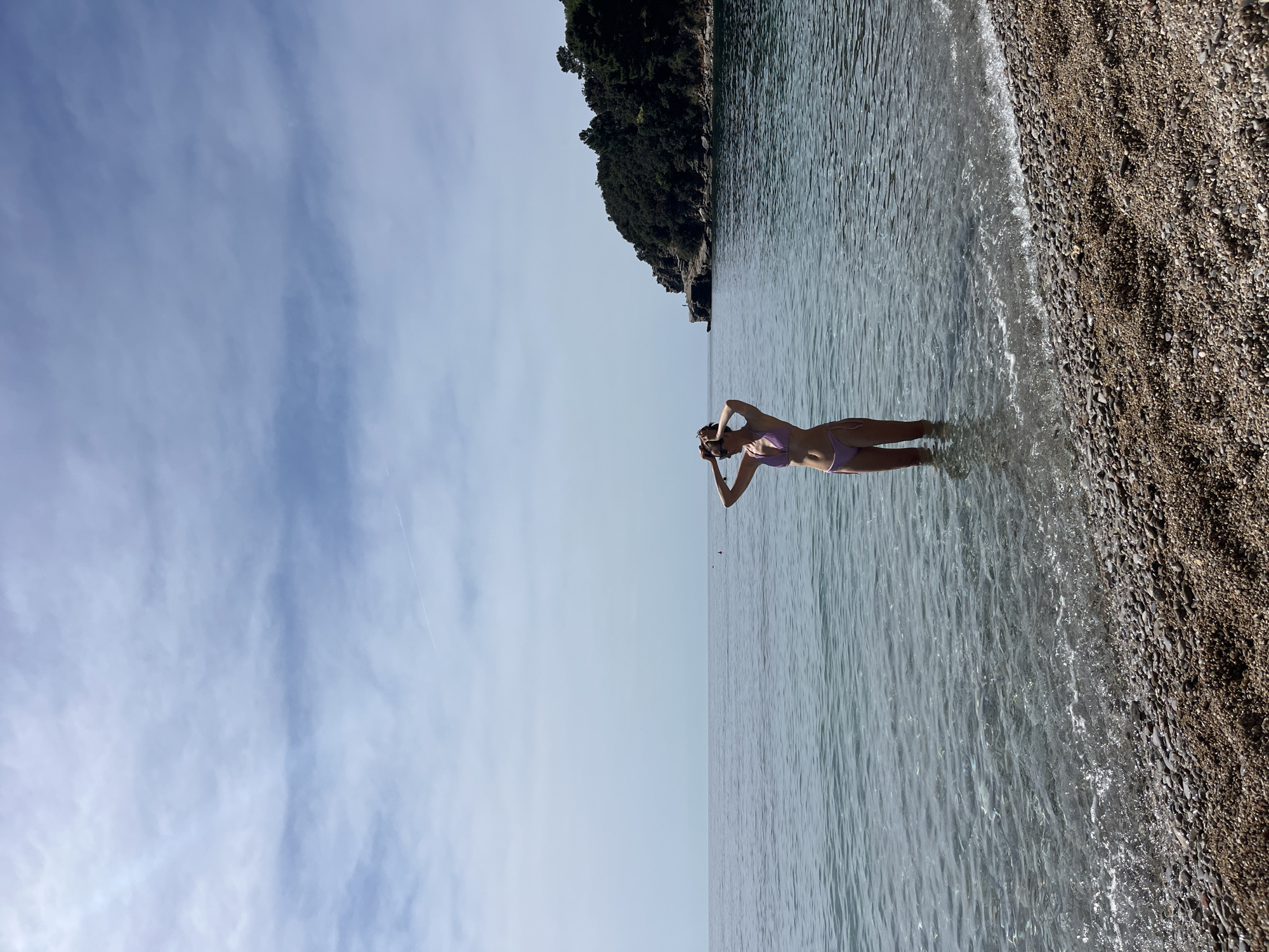 Woman in pink swimsuit enjoys morning waters in Budva