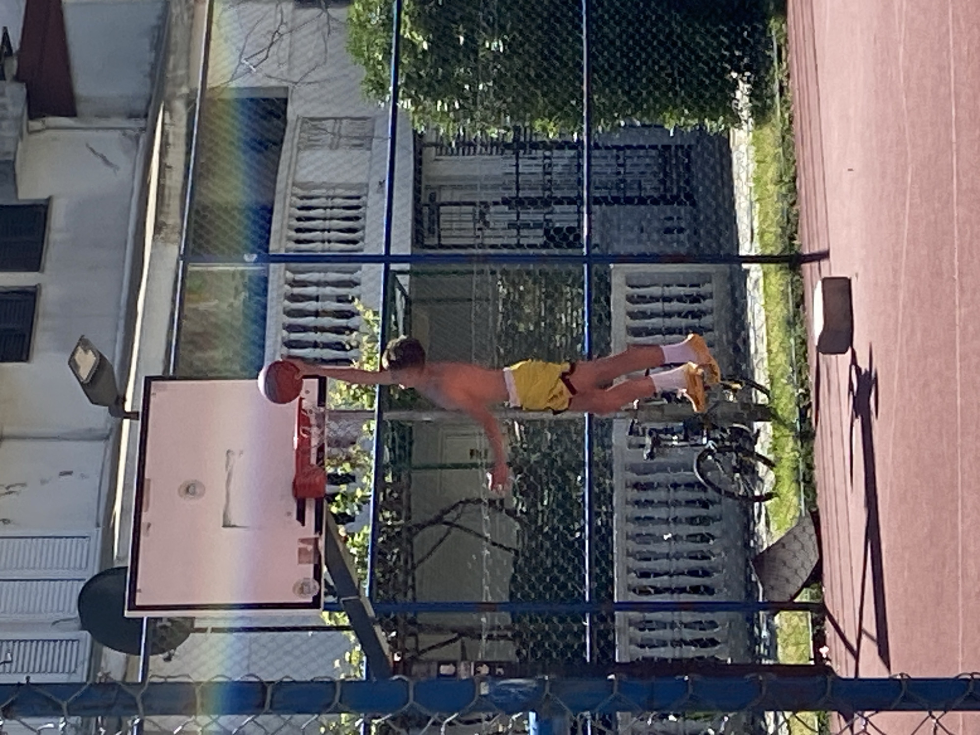 Young player shoots hoops in sunny Budva courtyard