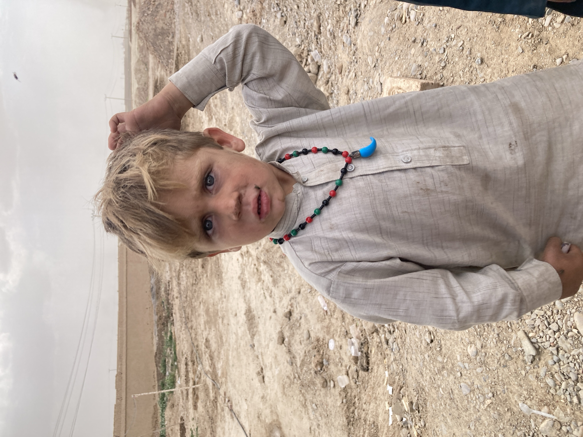 Two boys spotted on dusty ground in rural Pakistan