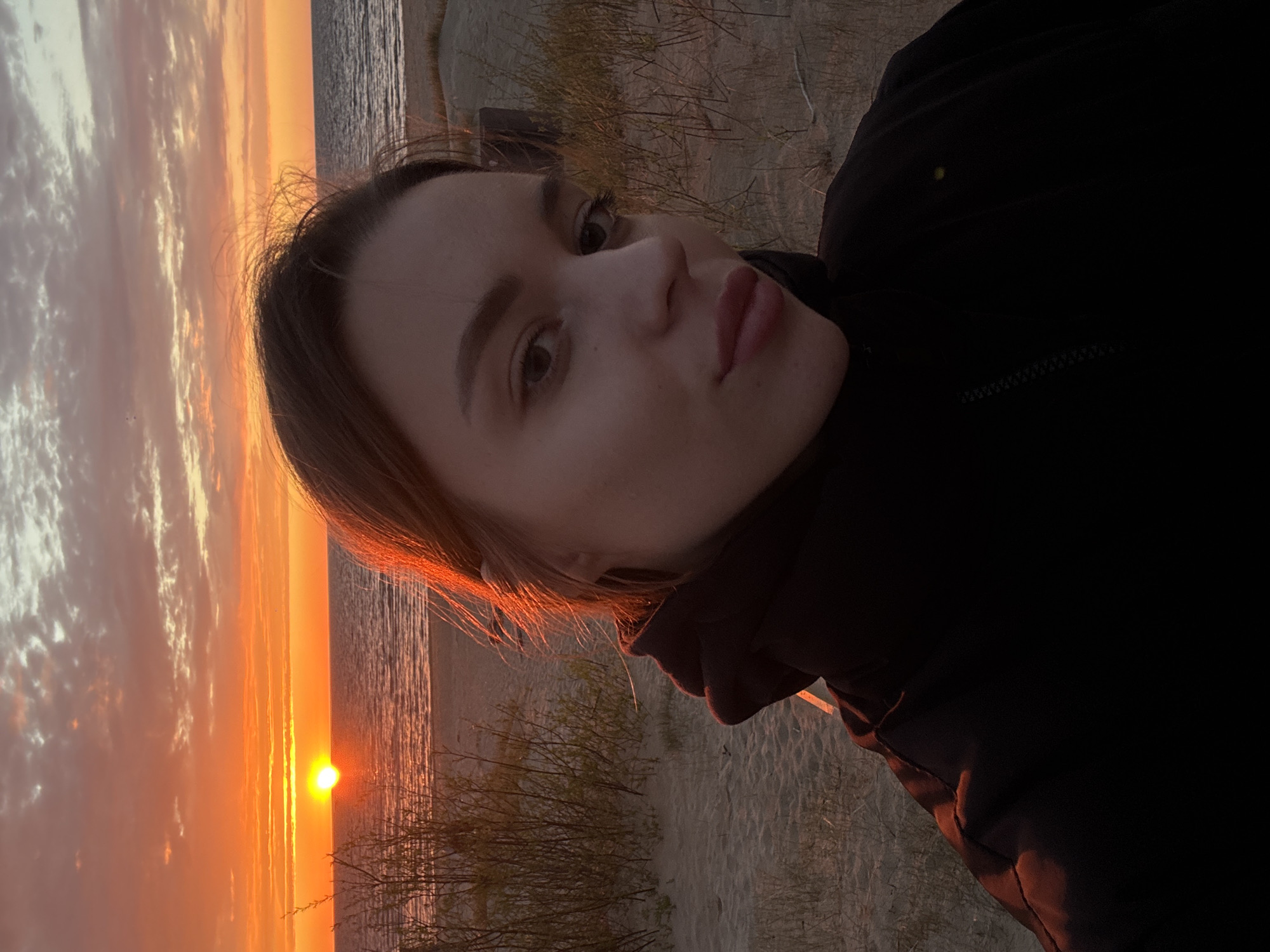 Woman photographed against sunset seascape in Ādaži, Latvia