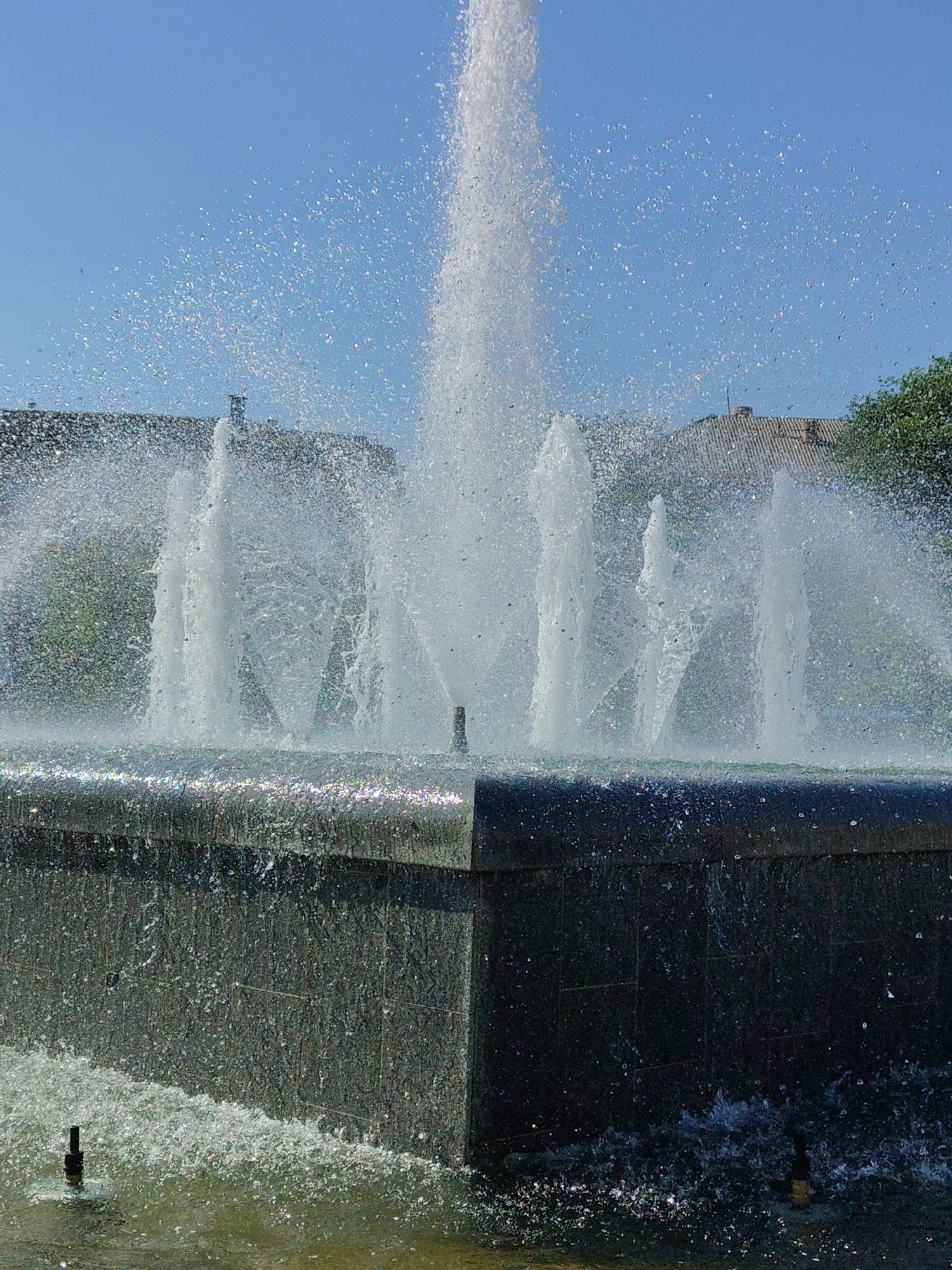Urban fountain with bronze dancer statue draws pedestrian activity