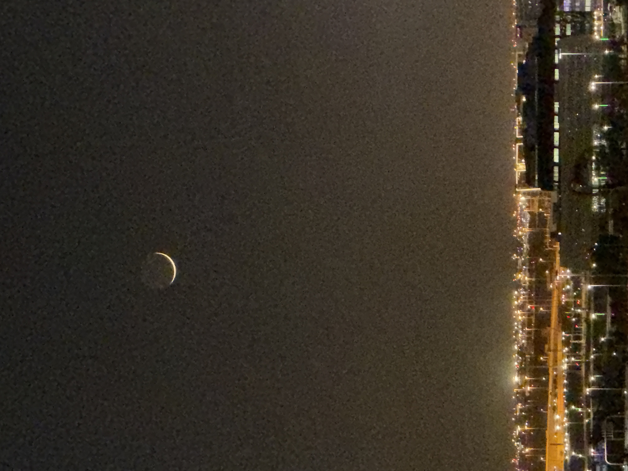 Crescent moon night over a glowing modern city skyline