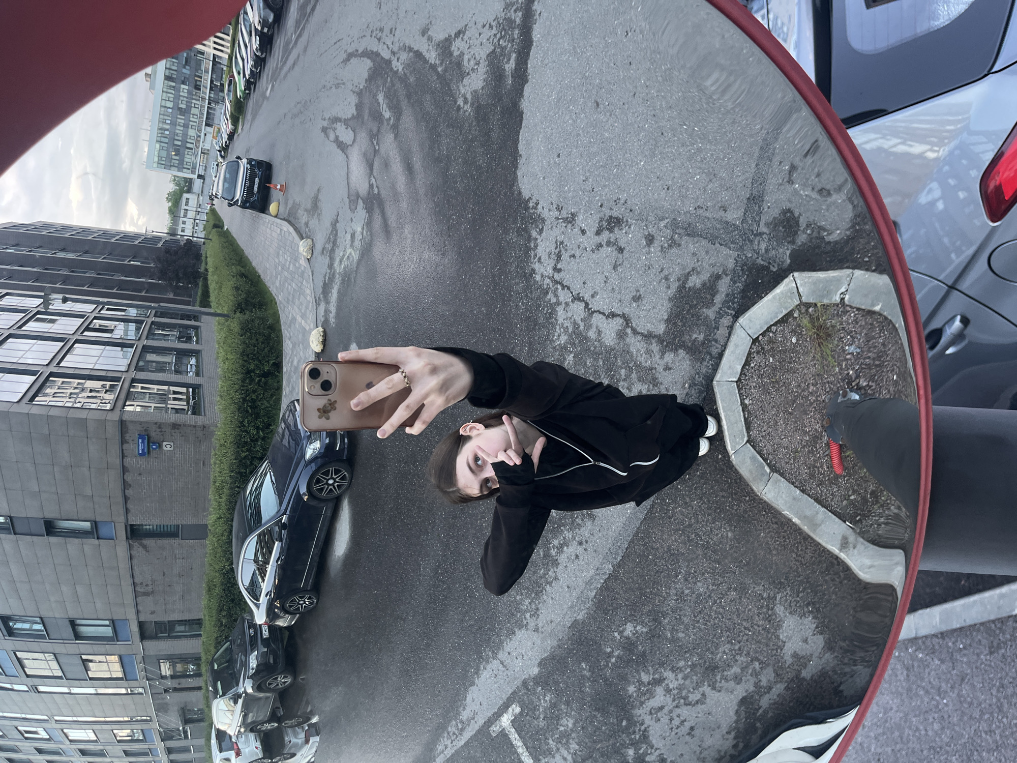 Woman takes distorted selfie in convex mirror on Russian street