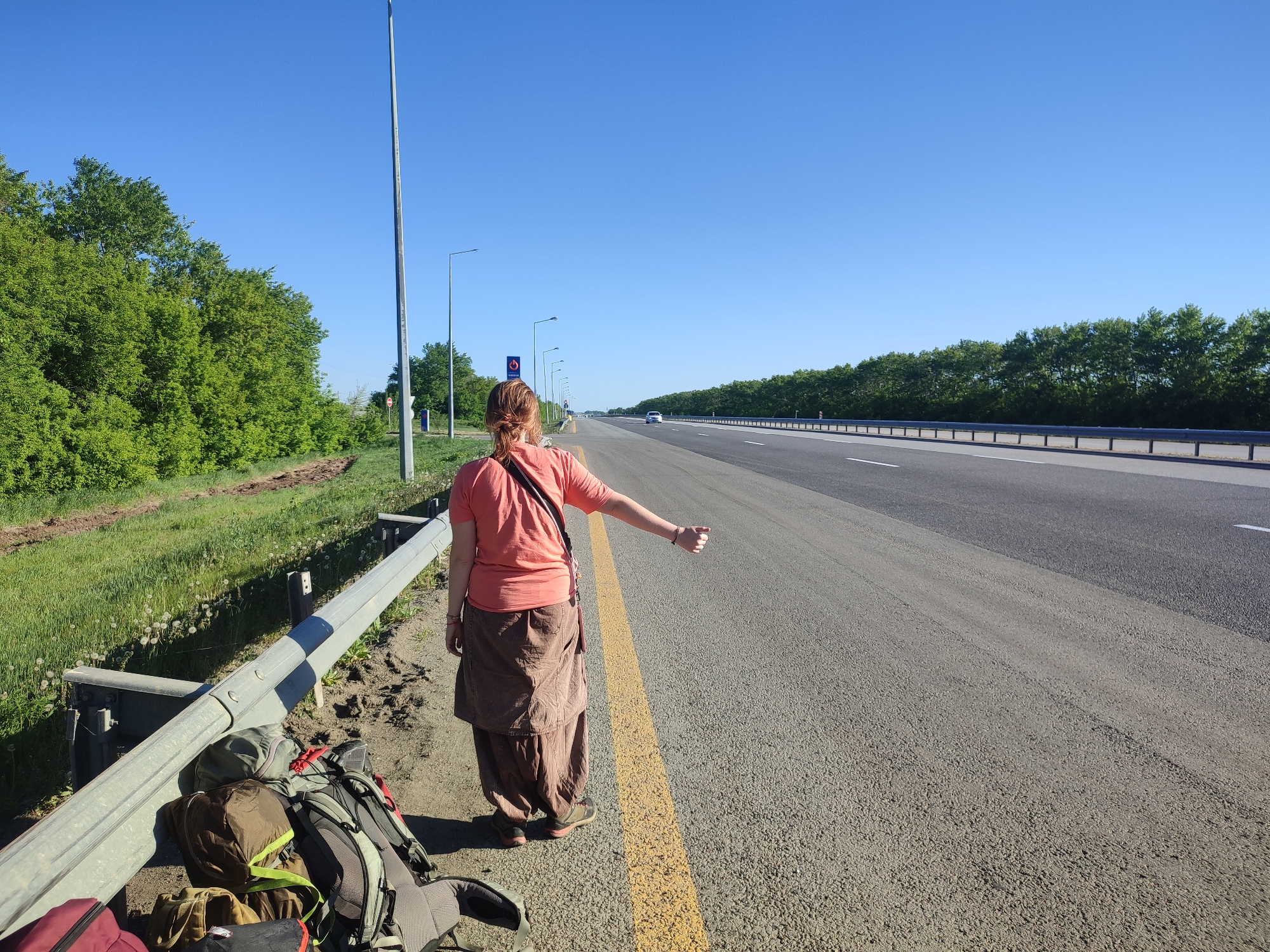 Woman hitchhikes on highway in rural Kazakhstan