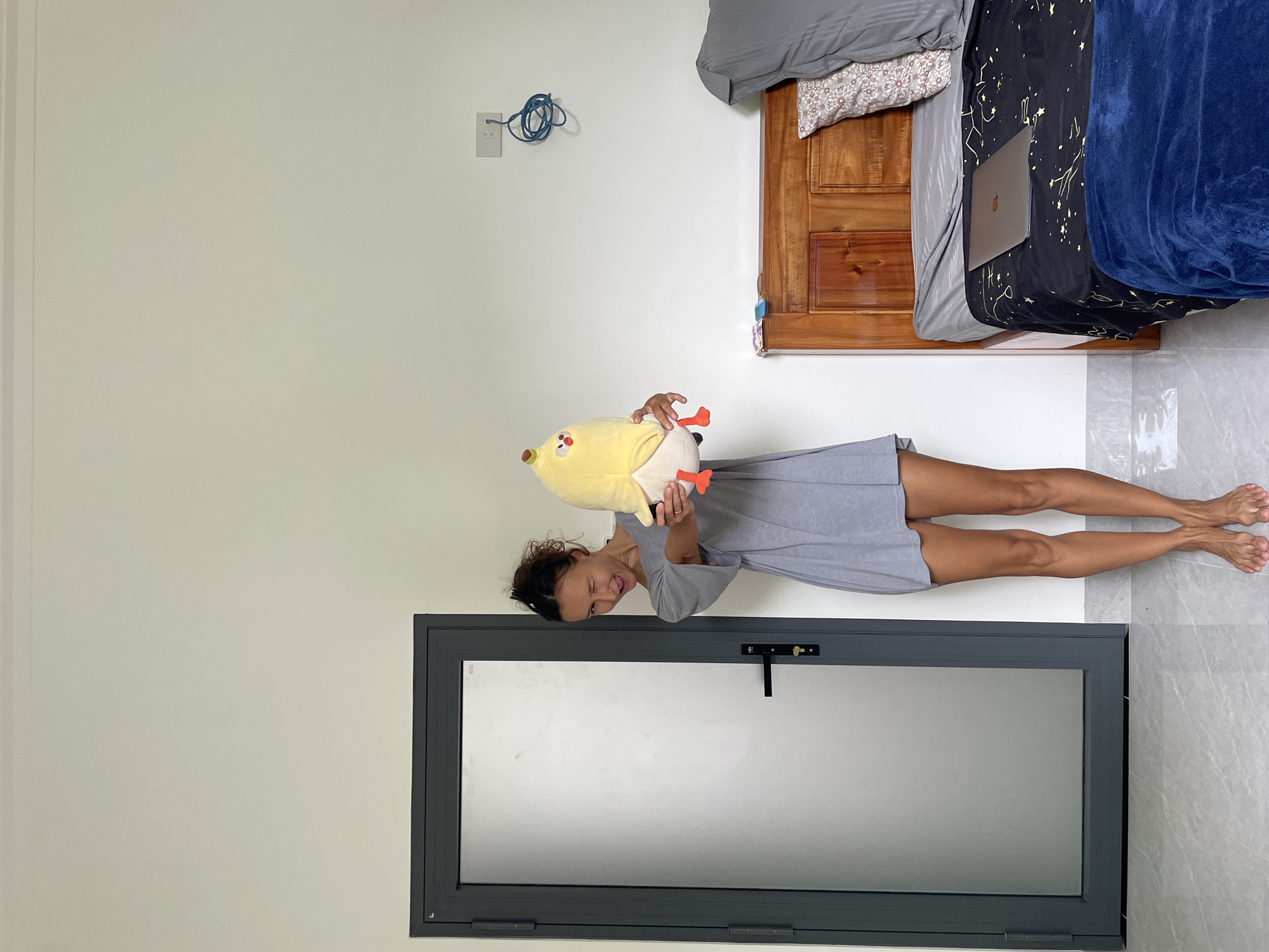 Woman poses, exercises in Mũi Né bedroom during morning session