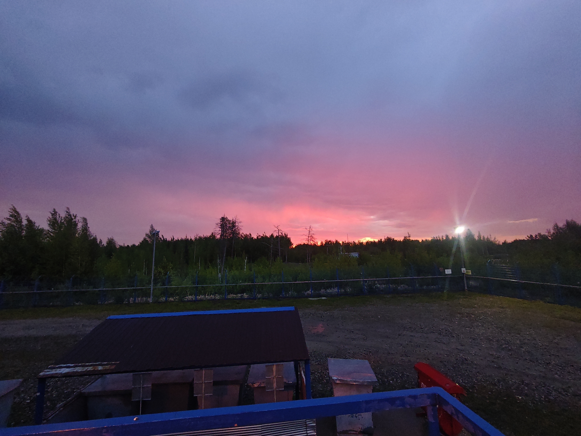 Vibrant sunset displays dramatic colors across rural Russian landscape