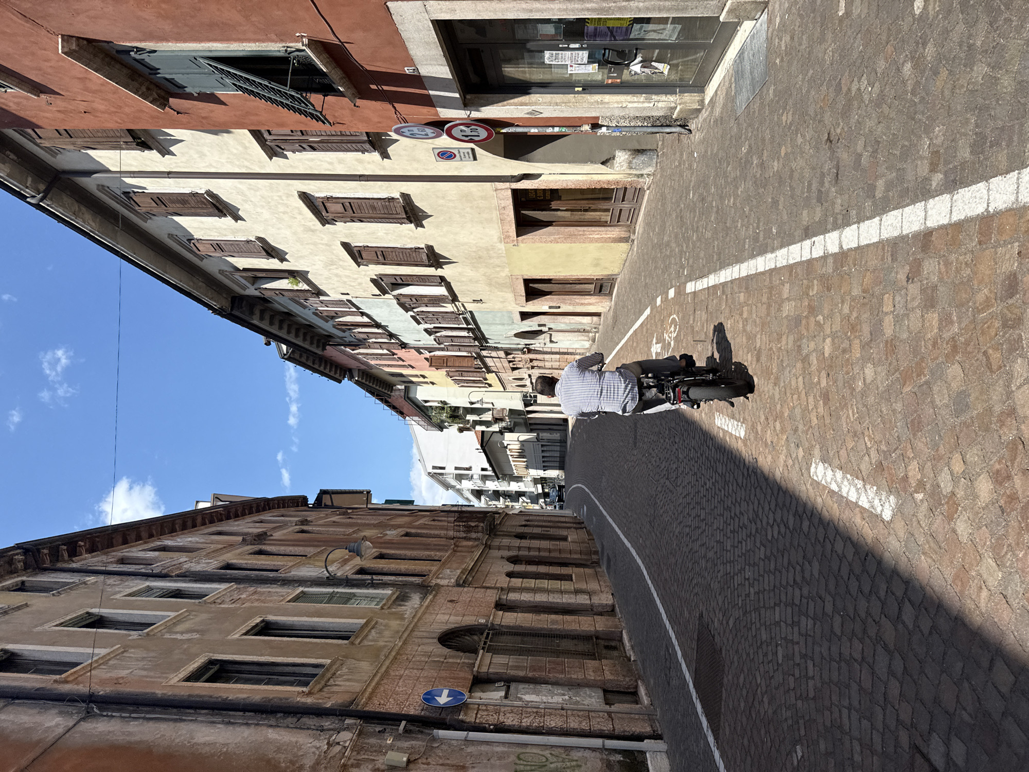 Cycling through Trento's old town streets on a summer afternoon