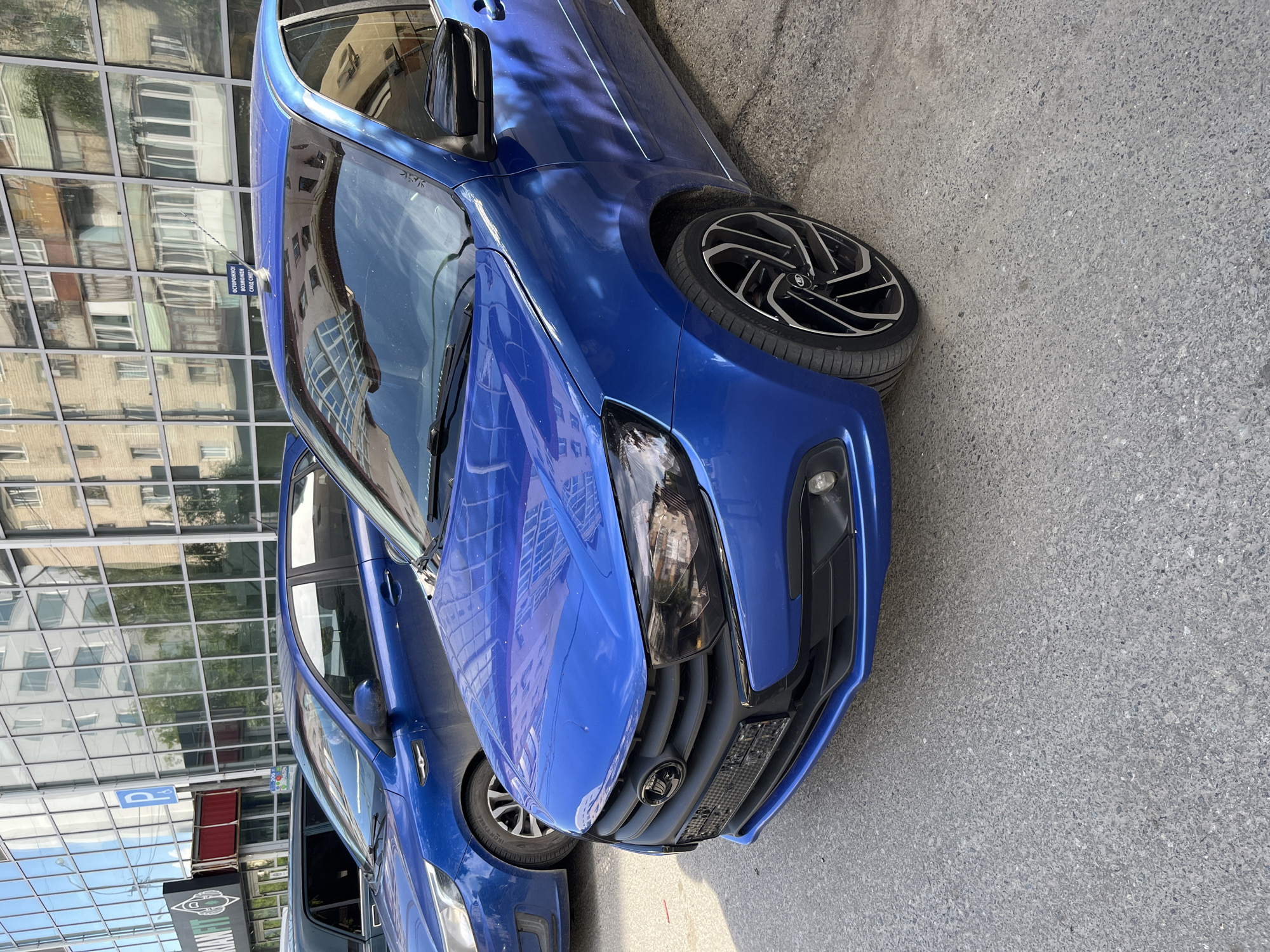 Blue Lada parked outside modern building, inside and out