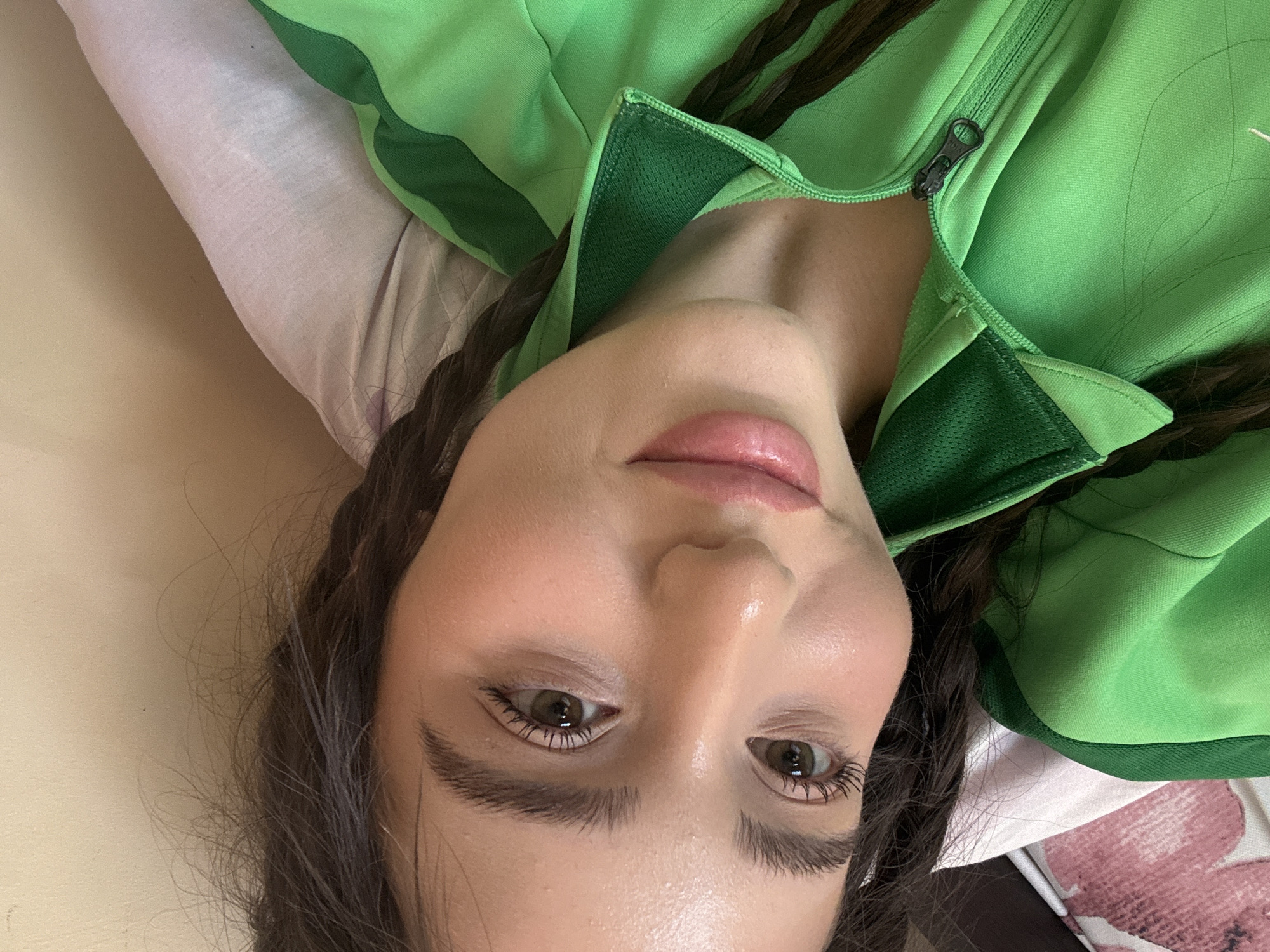 Woman in green tracksuit rests on patterned surface