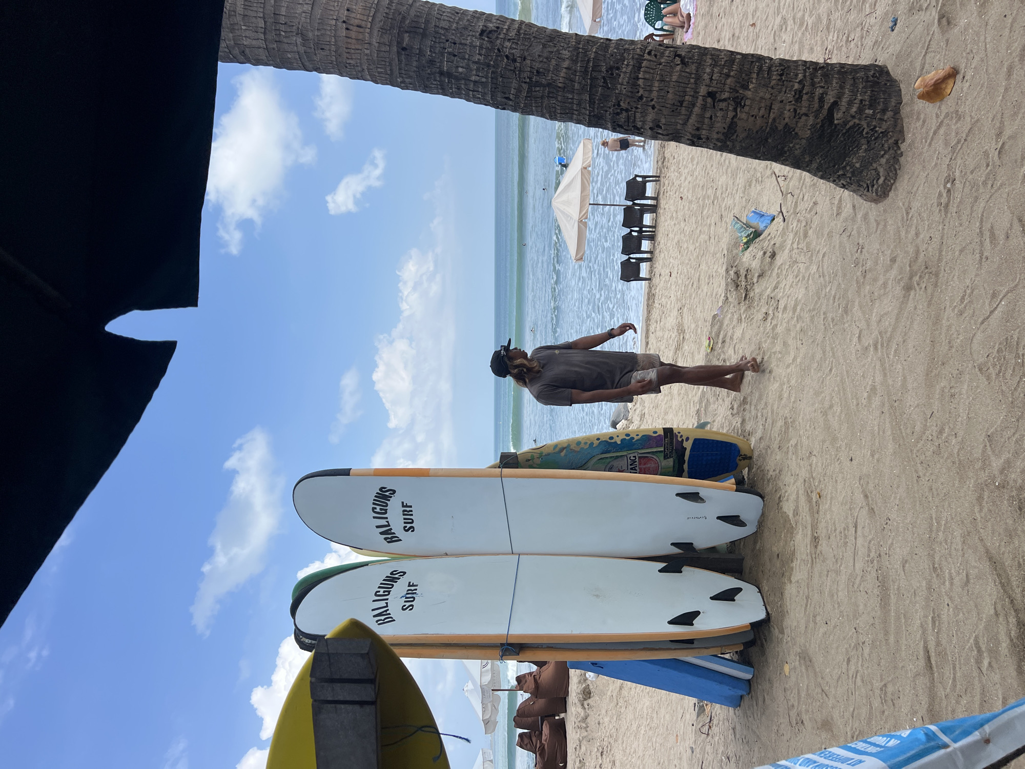 A busy morning on Kuta Beach with surfers and beachgoers