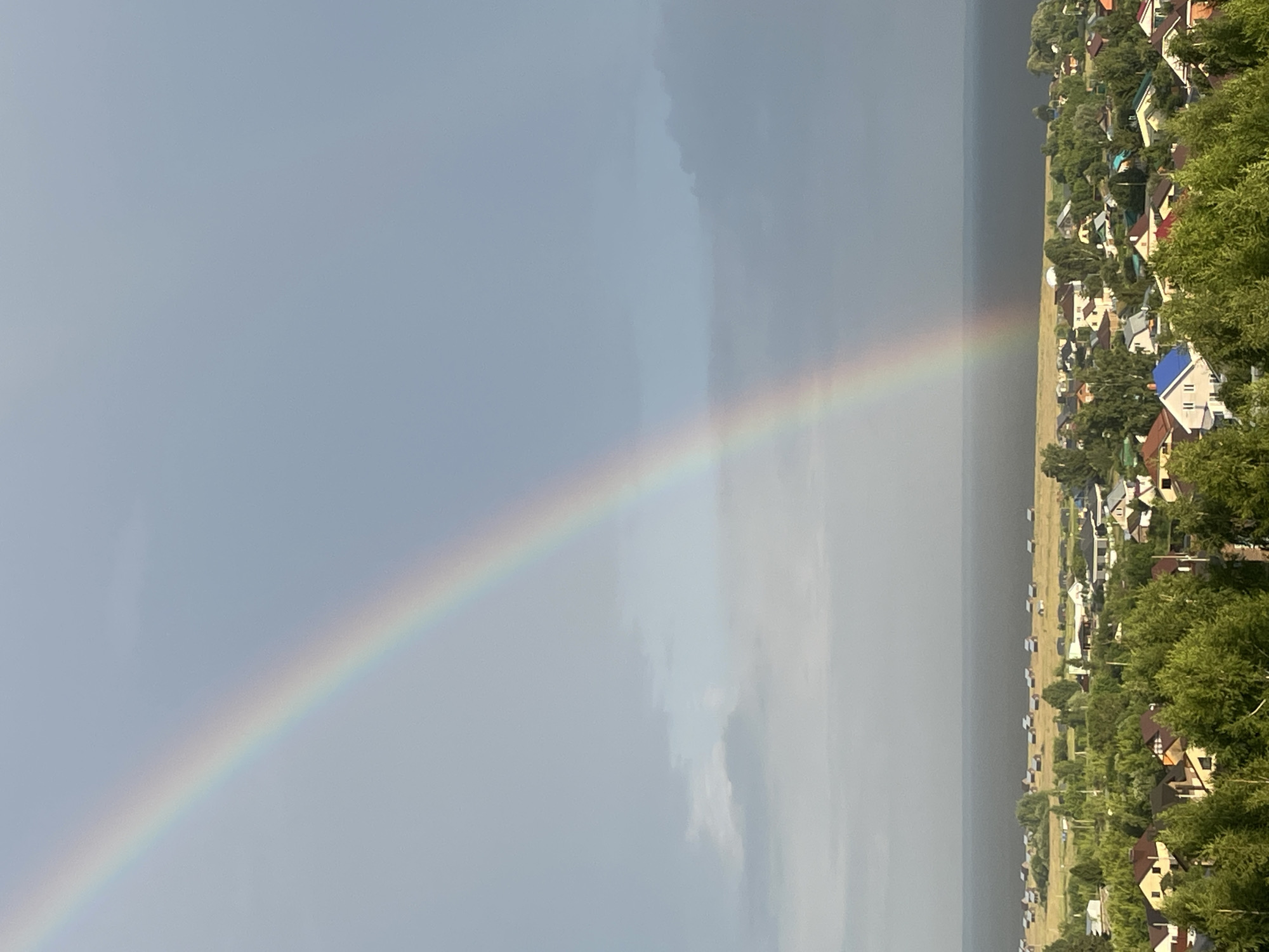 Rainbow over Laishevo's rooftops and waterfront after a storm