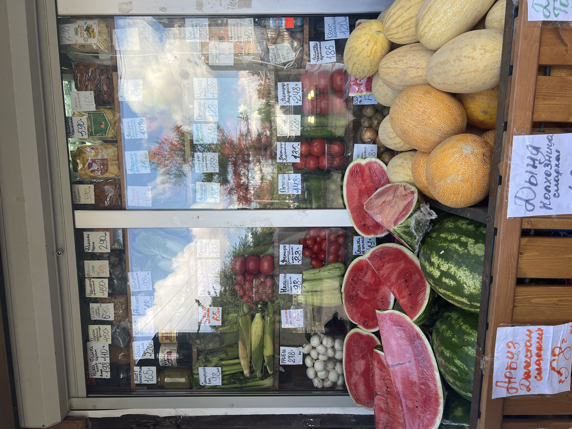 Street produce, berry bushes, a rusted sedan, and open sky