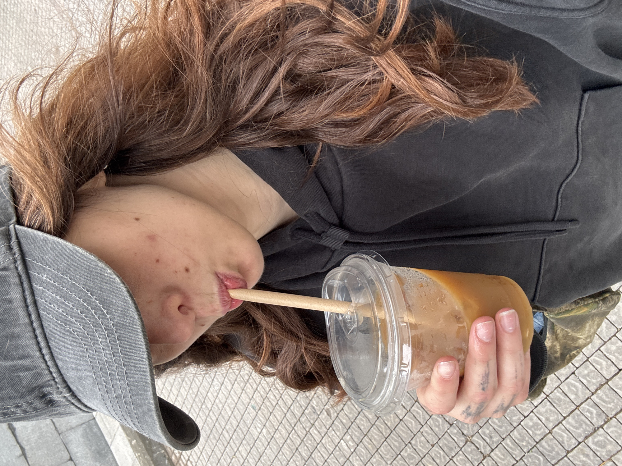 Woman drinks and takes photos simultaneously in Givatayim