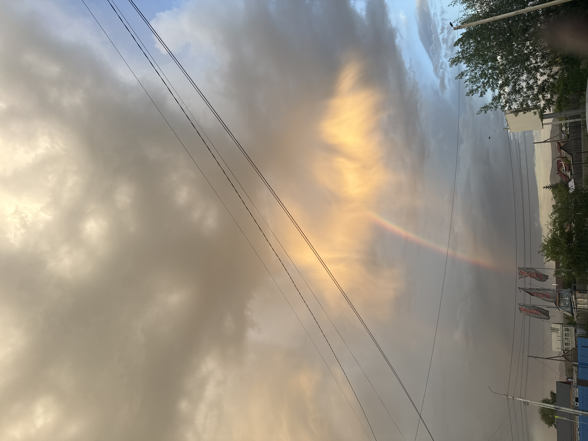 Rainbow appears over urban area amid dramatic clouds