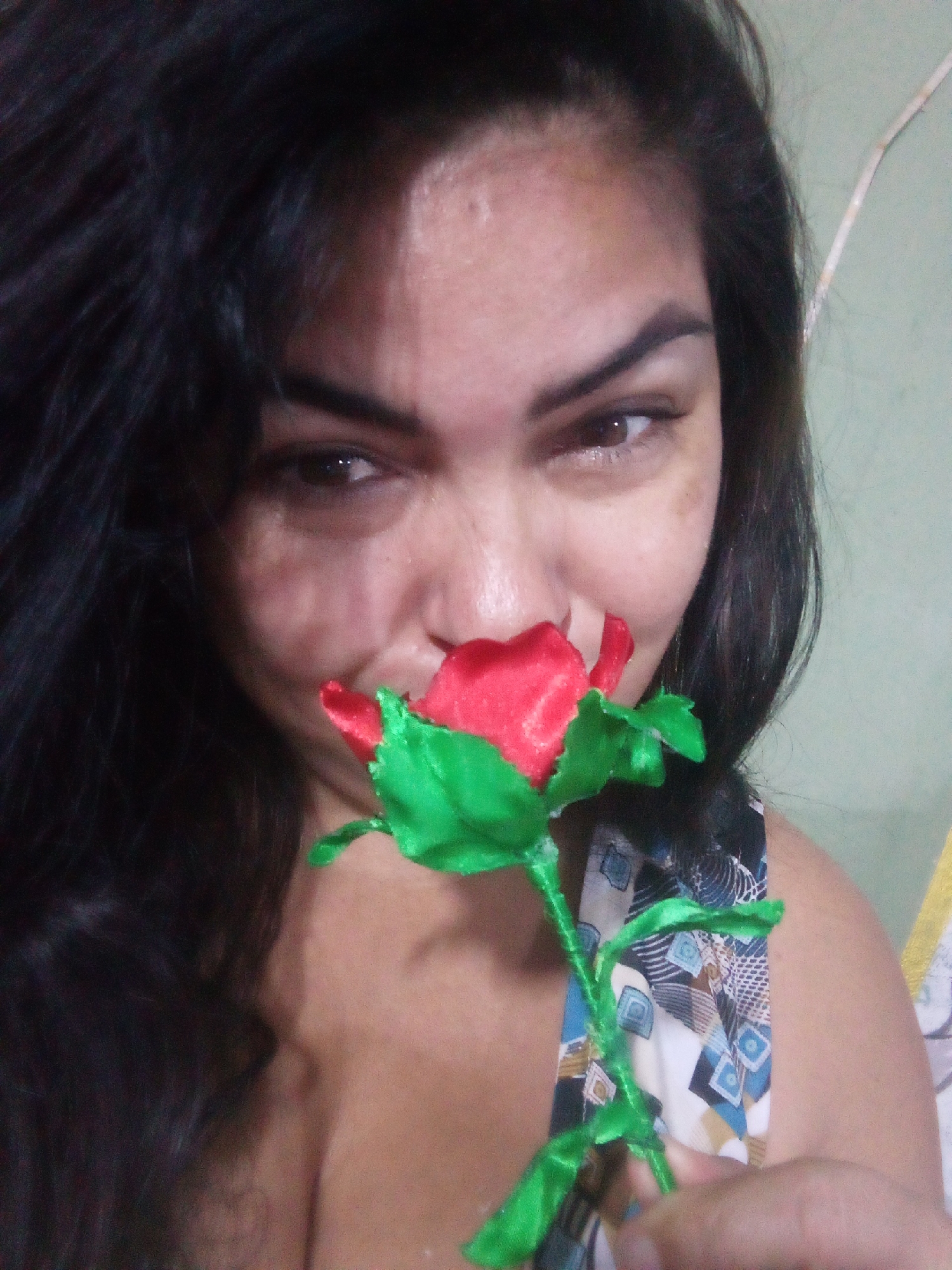 Person examines artificial rose during late-night crafting session