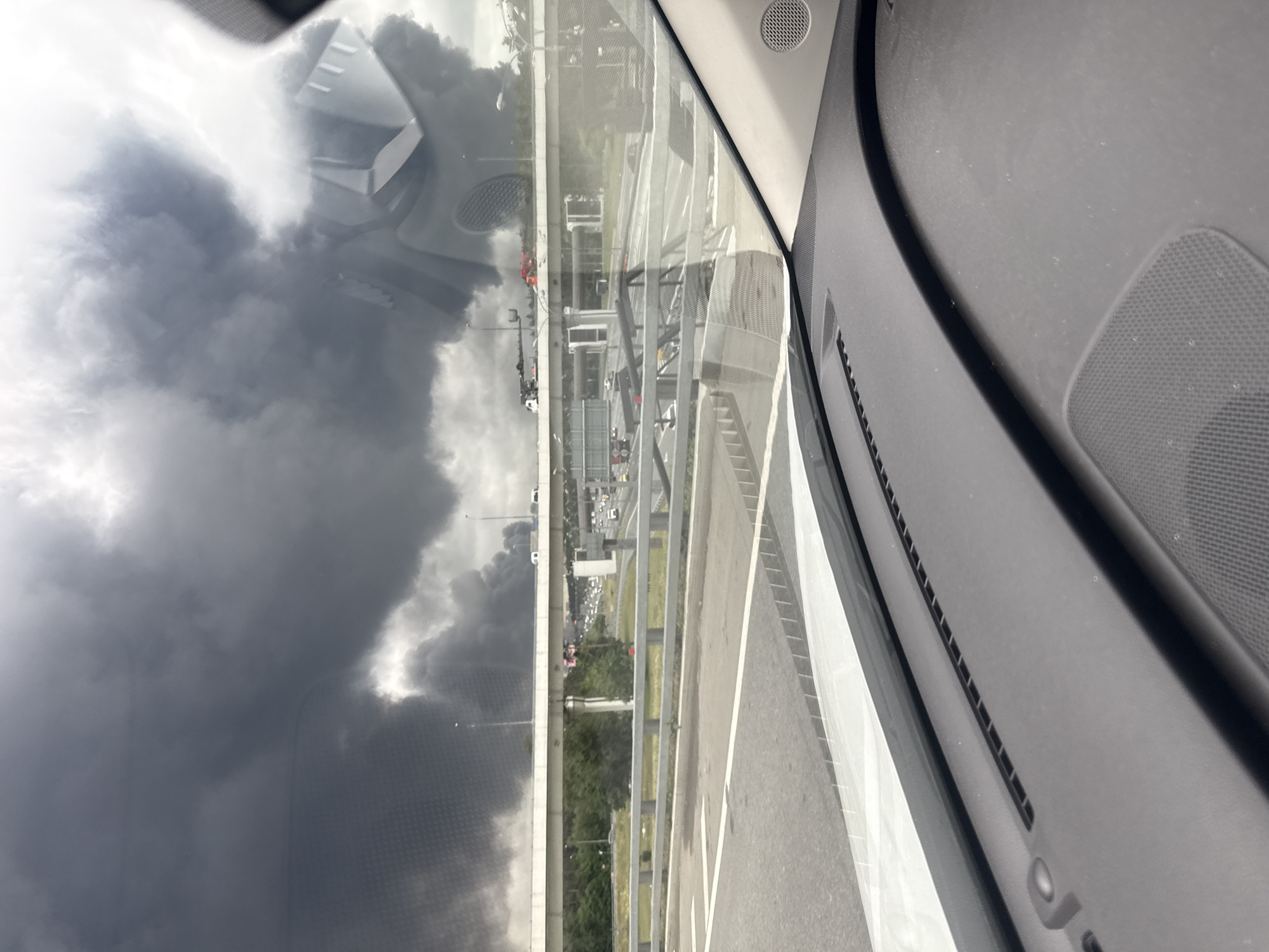 Large dark smoke plume rising over Moscow, seen from a vehicle