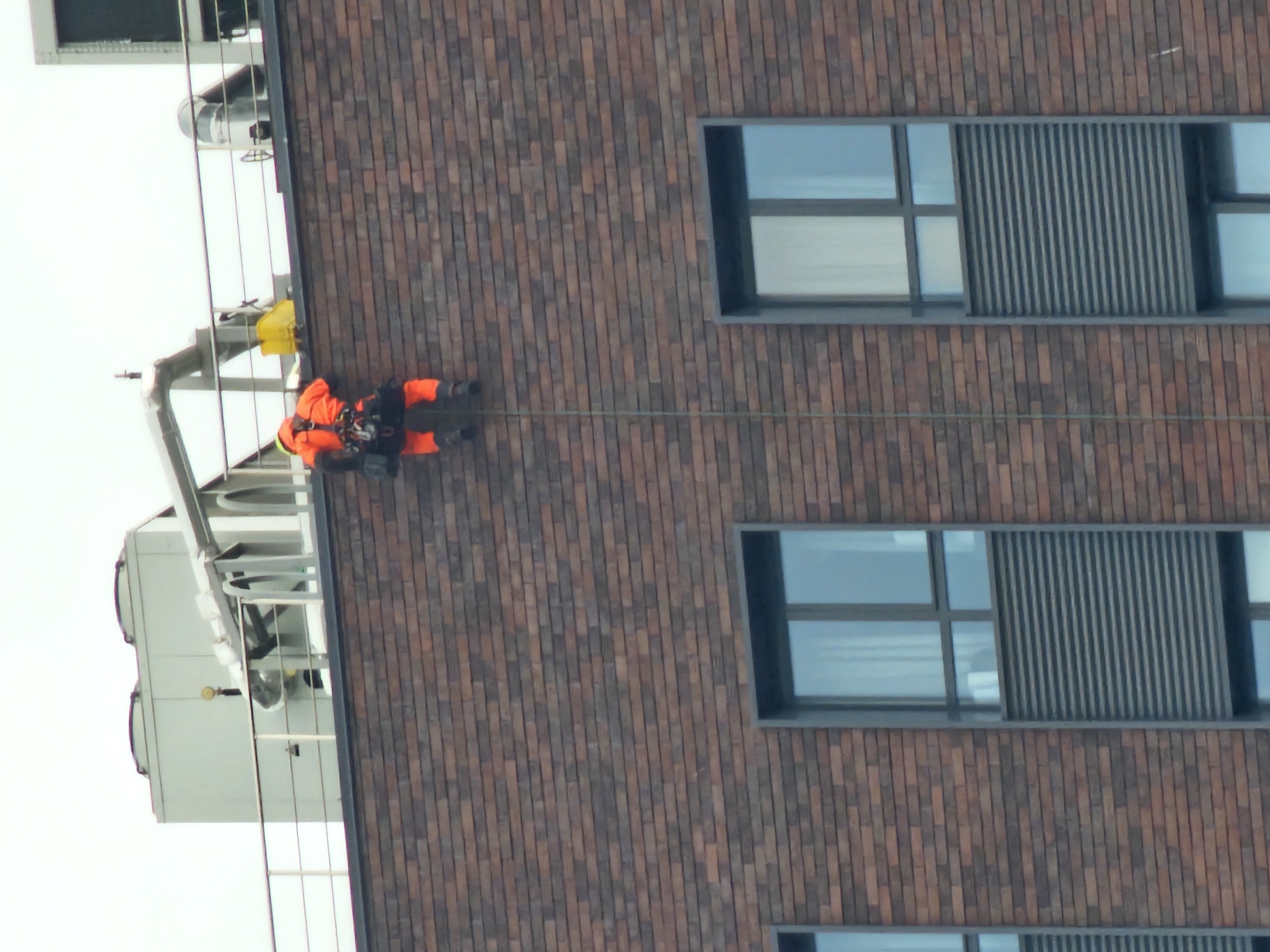 Worker rappels down building facade in Khimki, Russia