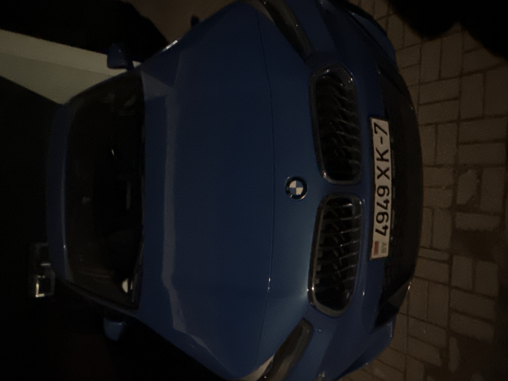 Cars parked on brick pavement during Minsk evening