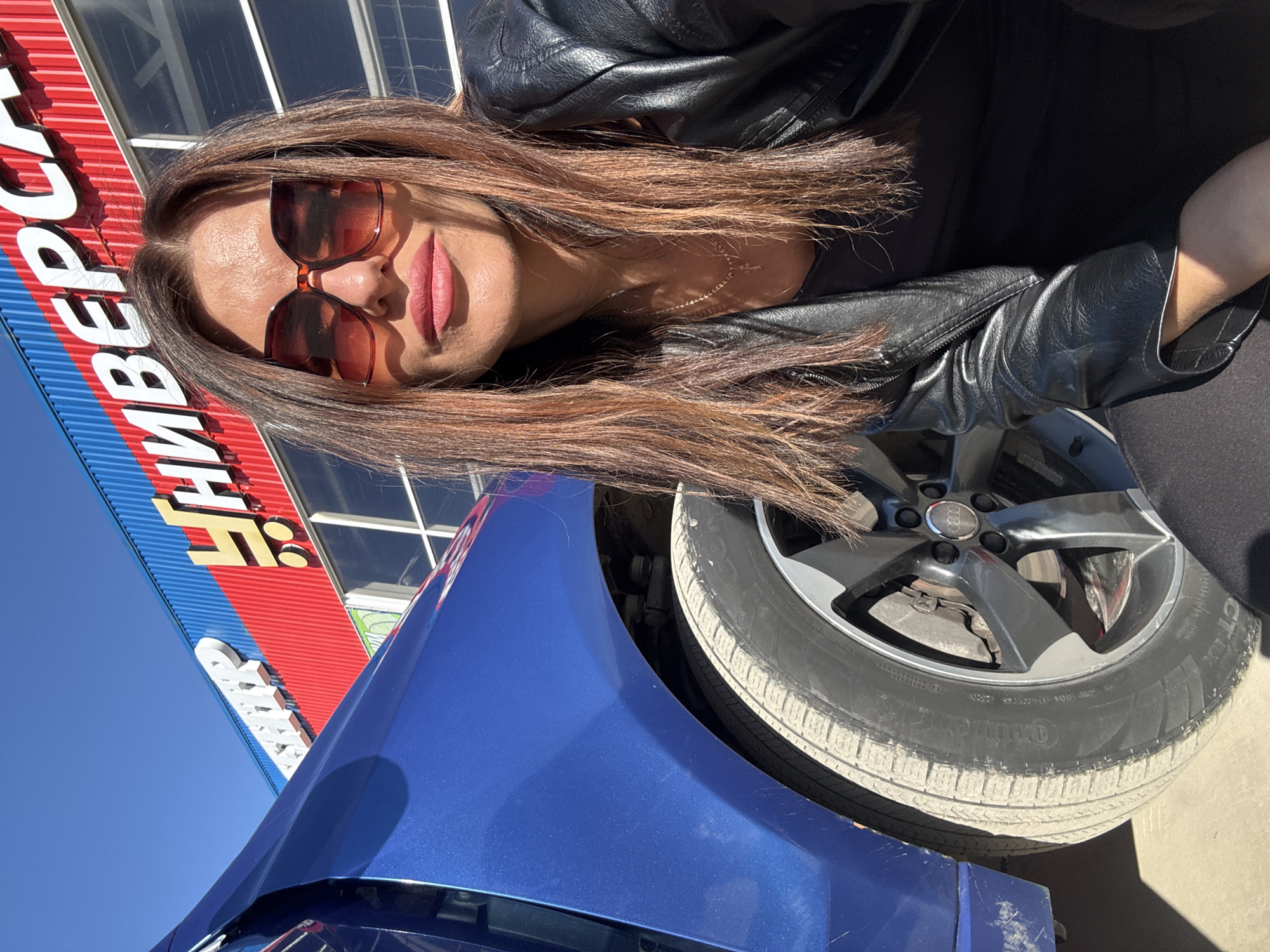 Woman documented around Chaikovsky with blue car during afternoon