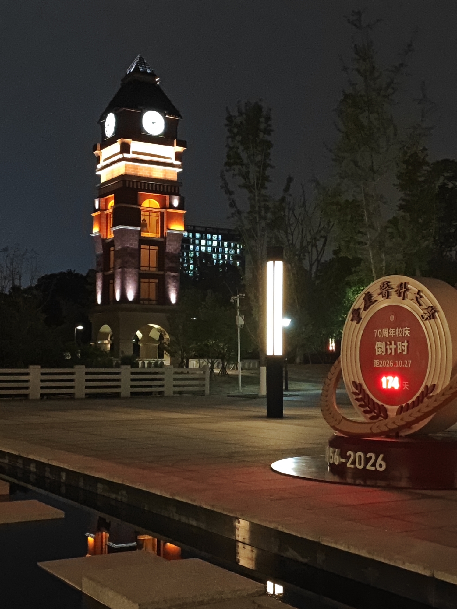 Illuminated clock tower photographed at night in Chongqing