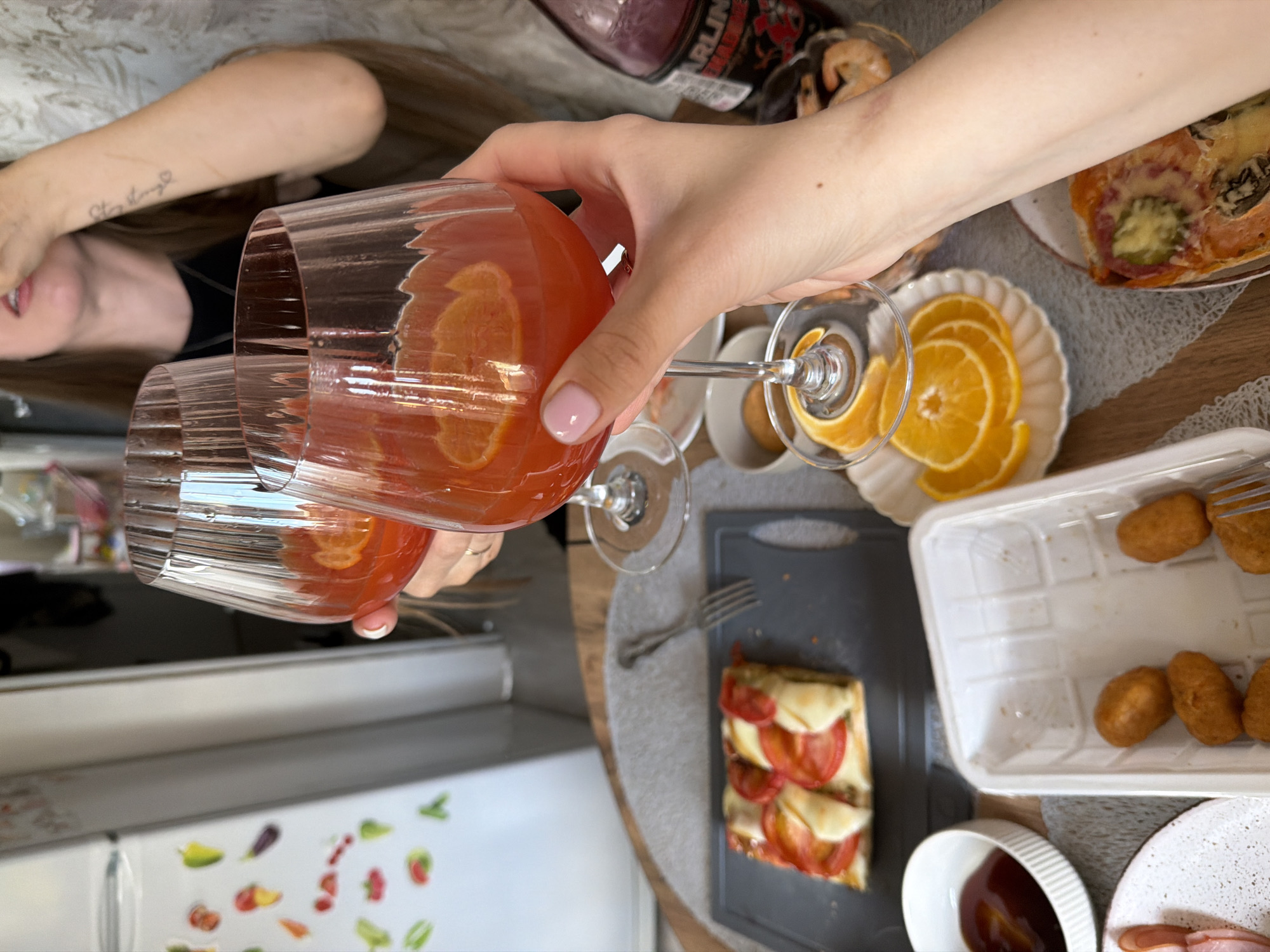 Women toast with drinks during home gathering in Reshetnikovo