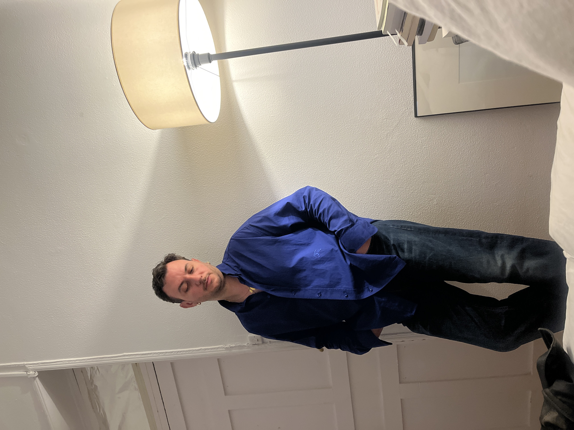 Man stands with eyes closed in Madrid room