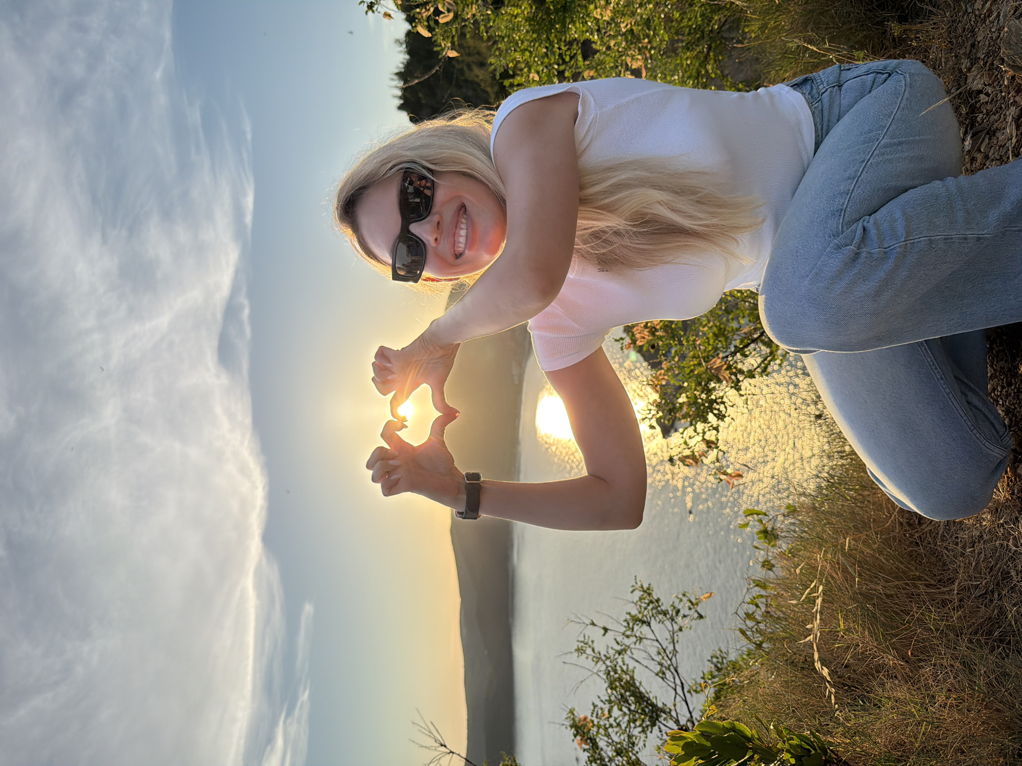 Heart gesture from a rocky Montenegrin bay overlook at sunset
