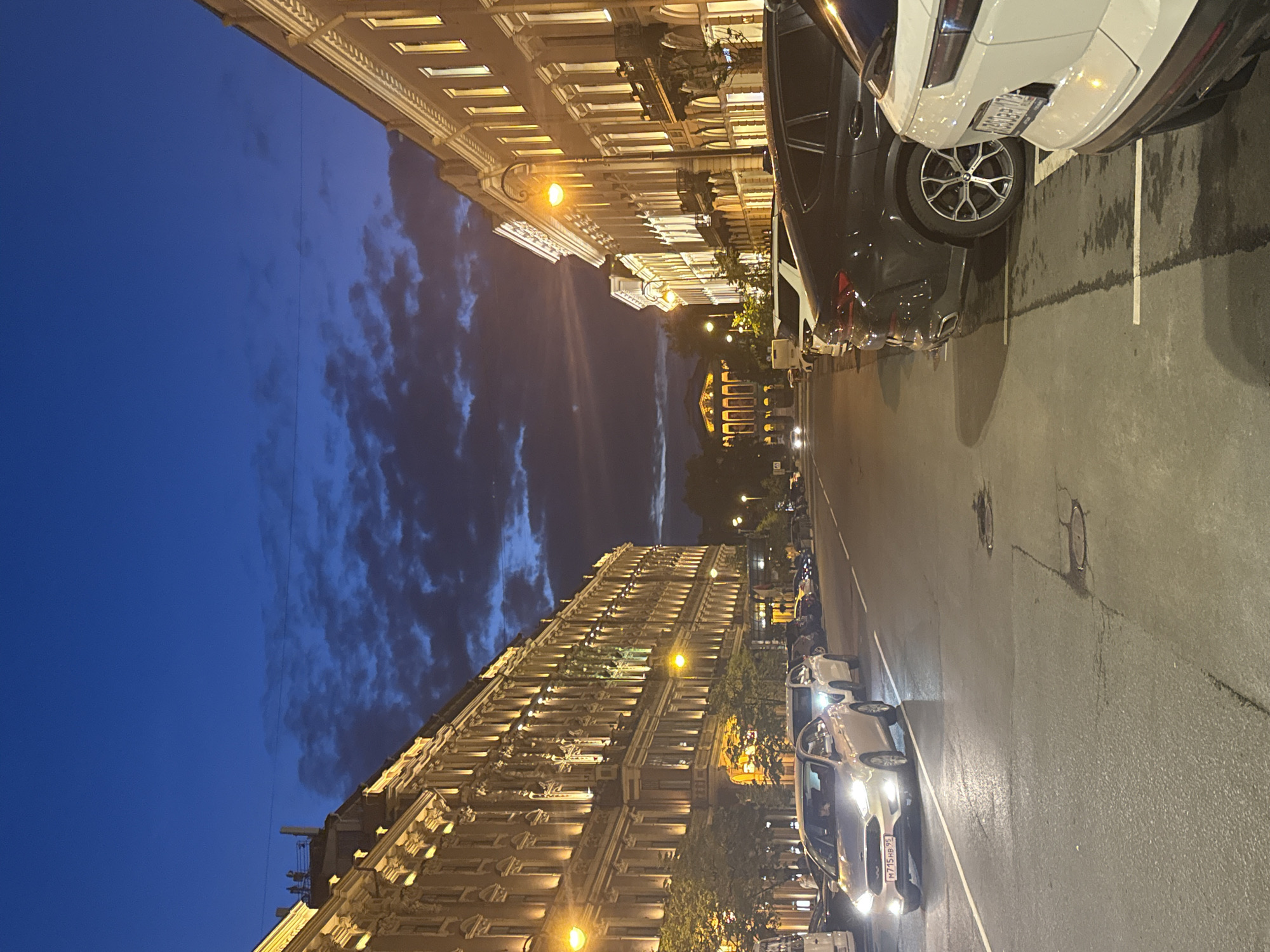 Wet Saint Petersburg street at night, grand architecture under streetlights