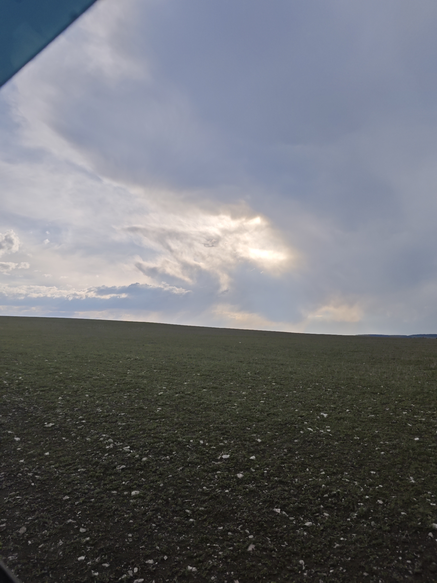 Cloudy skies over green fields documented near Yutsa, Russia