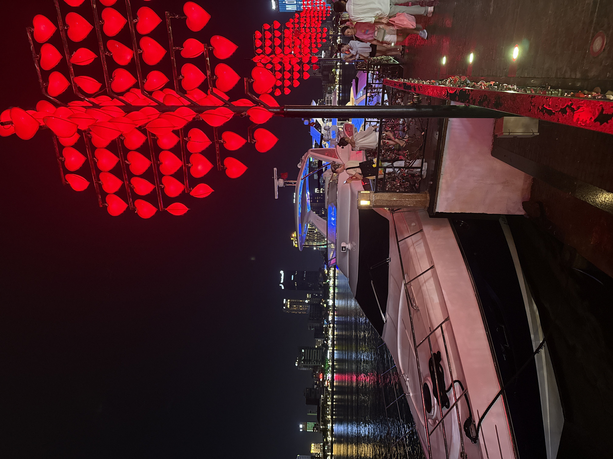 Nighttime festivities along Đà Nẵng waterfront feature heart lanterns, yacht