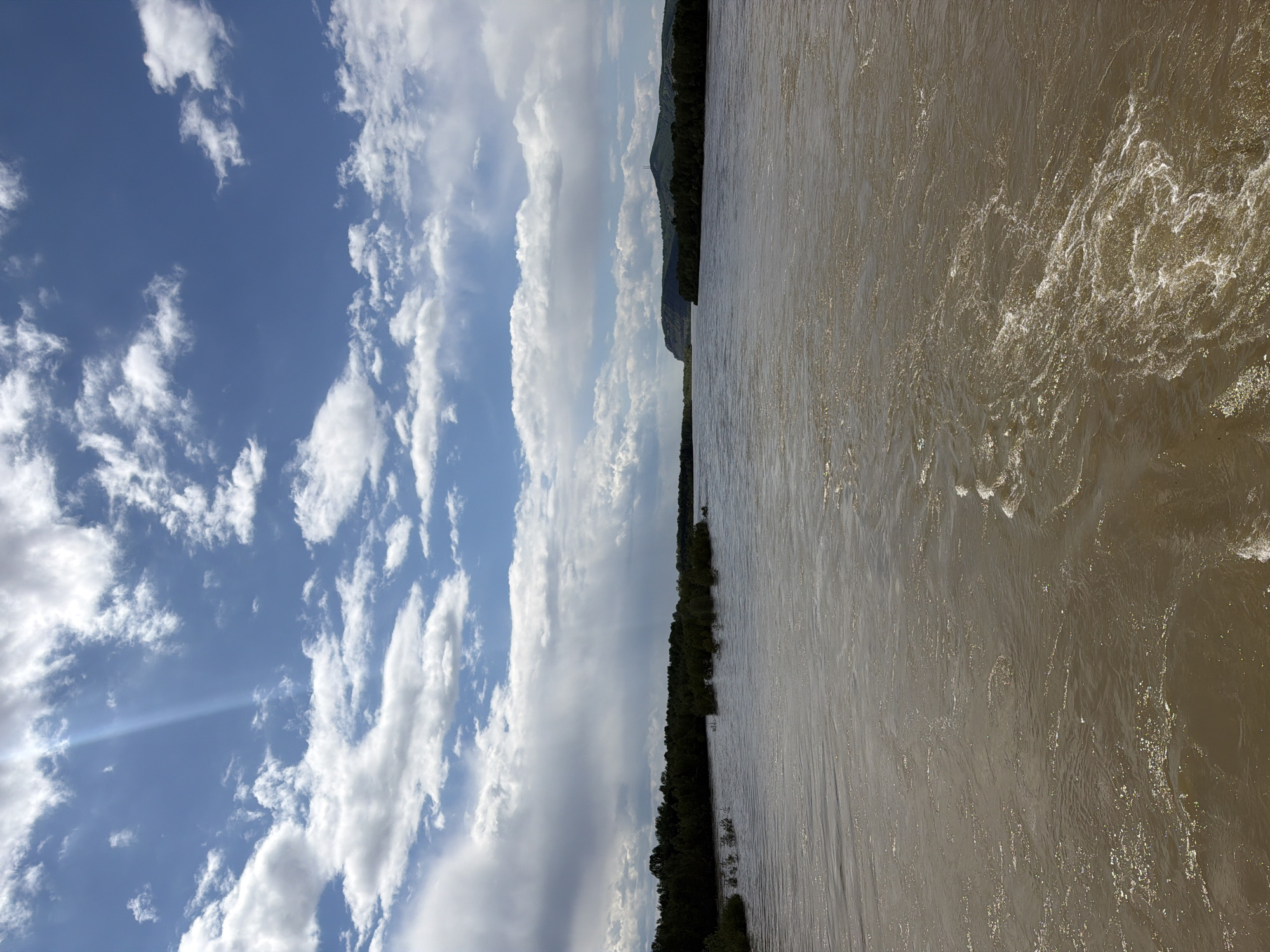 Morning river flows through Kuragino under partly cloudy skies
