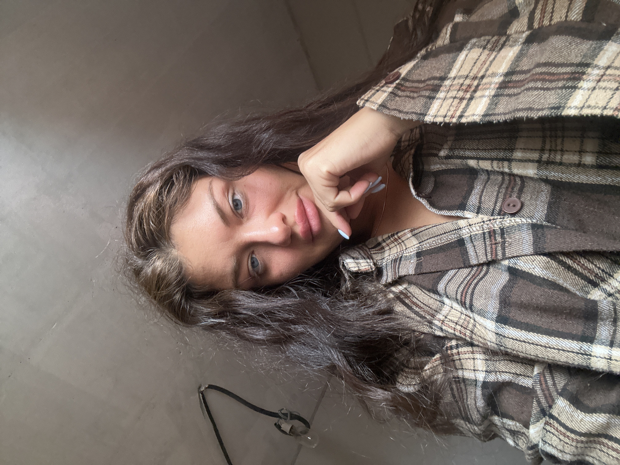 Woman takes selfie in plaid flannel shirt