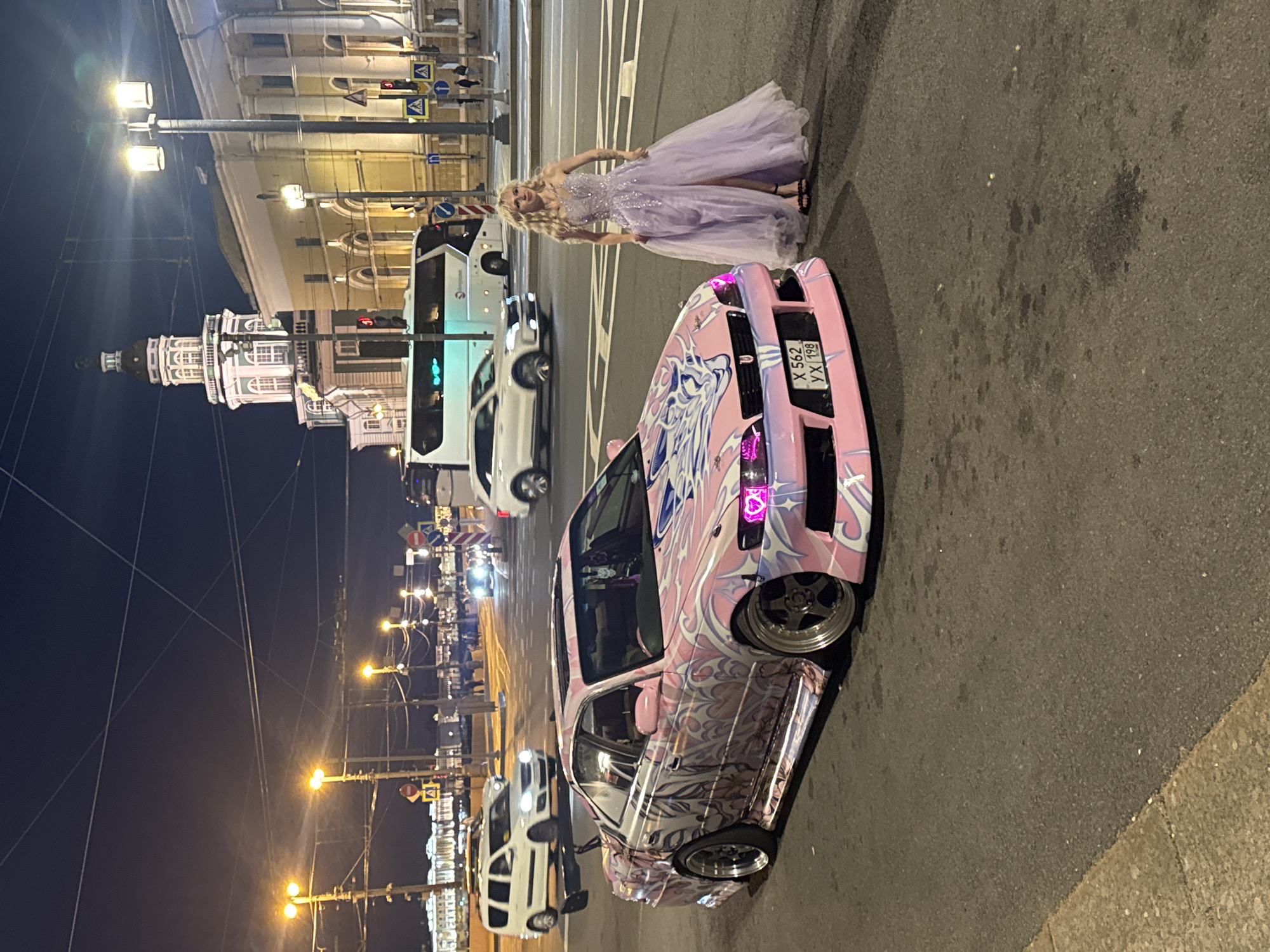 Anime-wrapped custom sedan and formal dress, city night