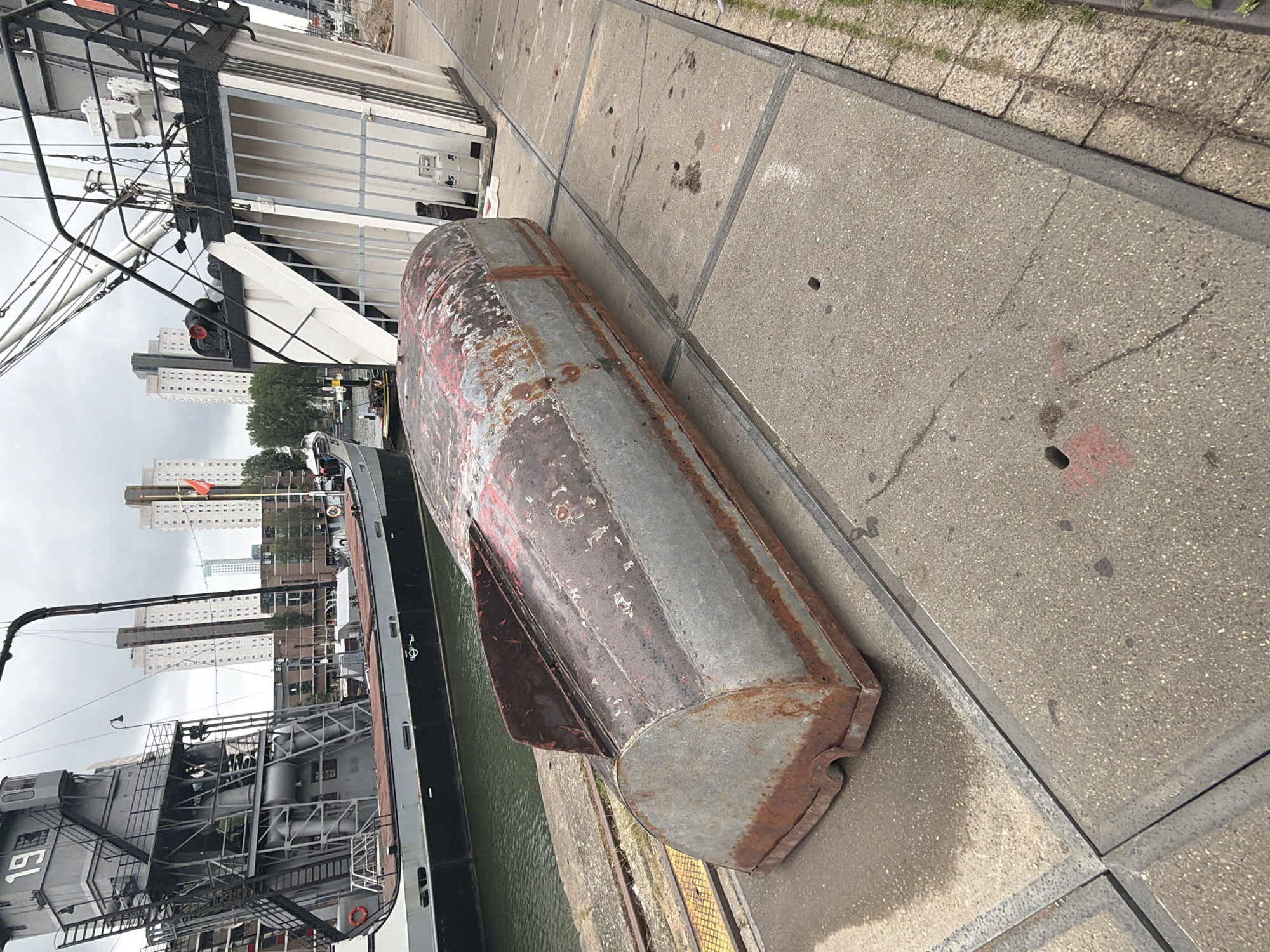 Tourist documents Rotterdam's historic harbor landmarks during overcast afternoon
