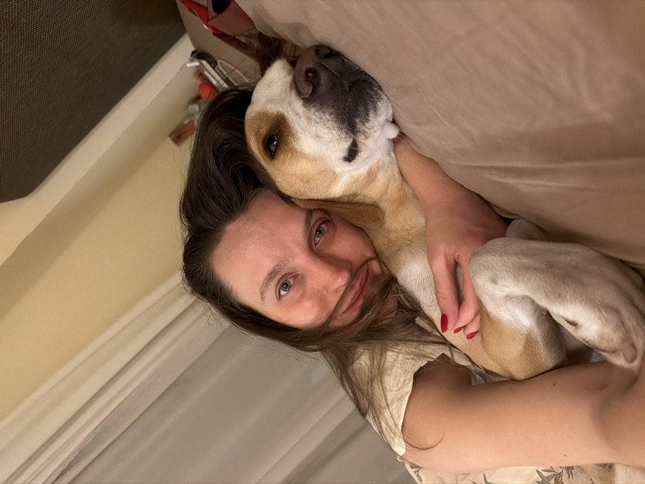Woman and dog share quiet bedroom moment in Budva