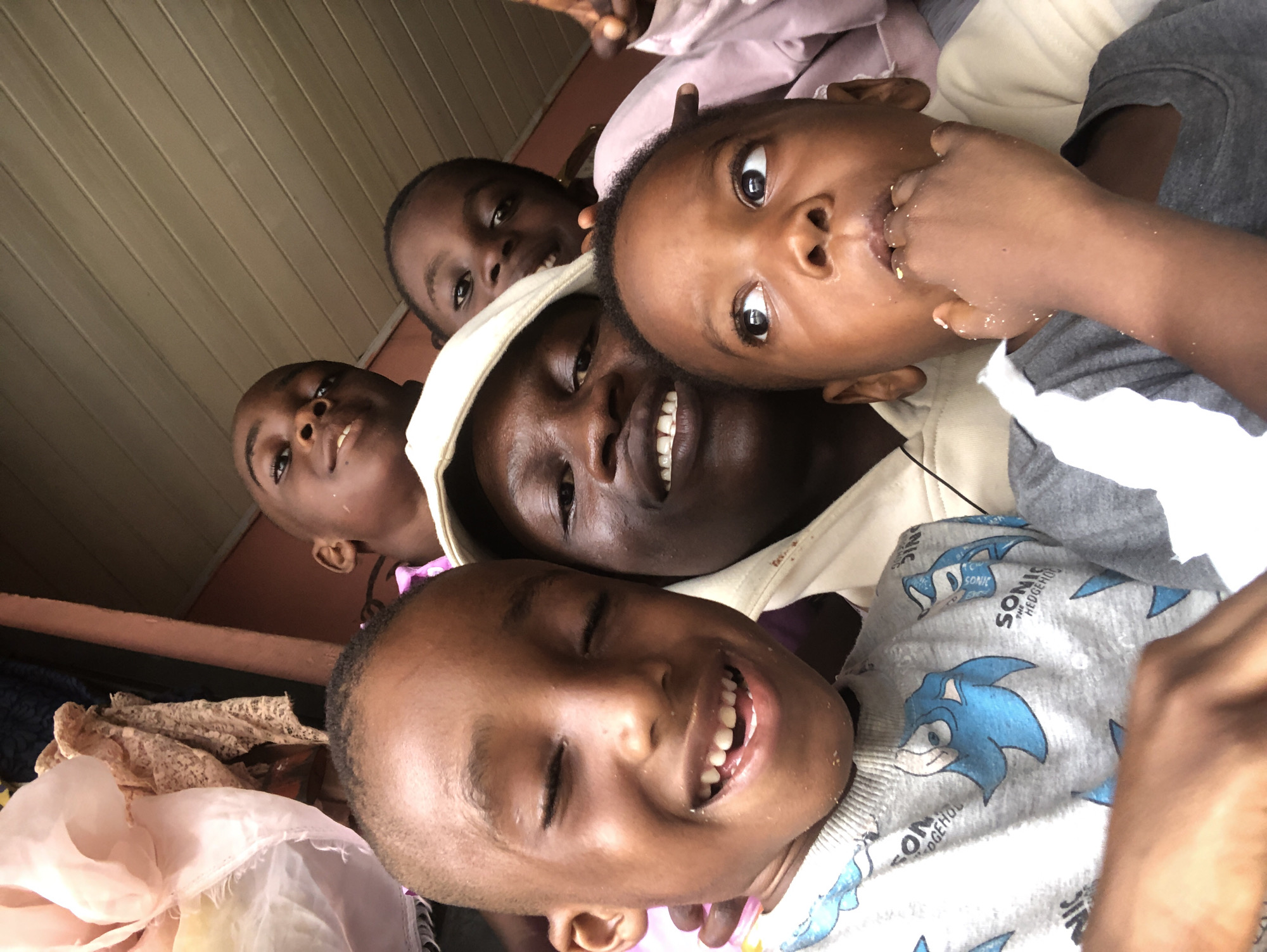 Group selfies with kids on a shaded porch in Ado, Nigeria