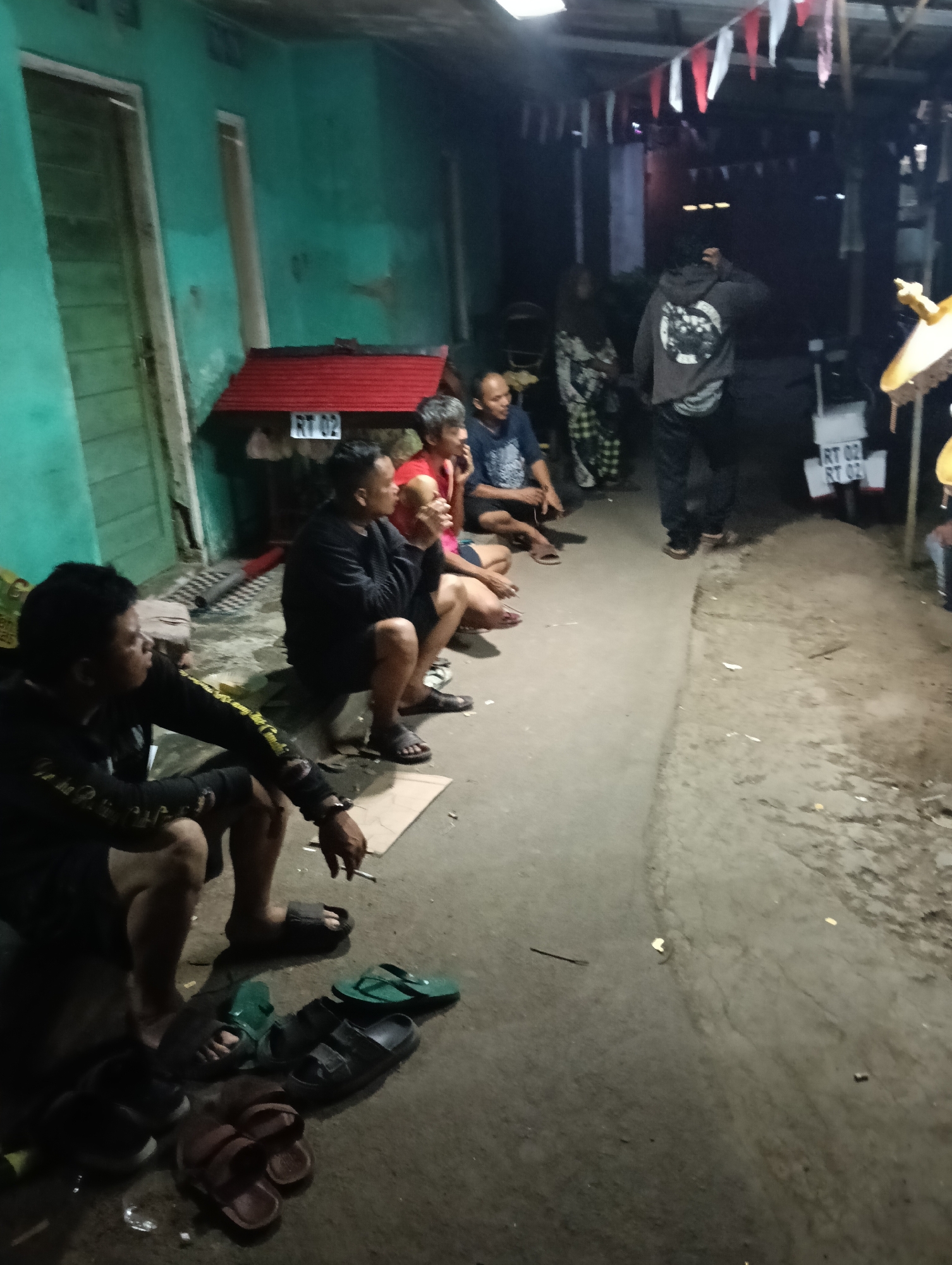 Evening community gathering in Tasikmalaya with crafting and scooter work