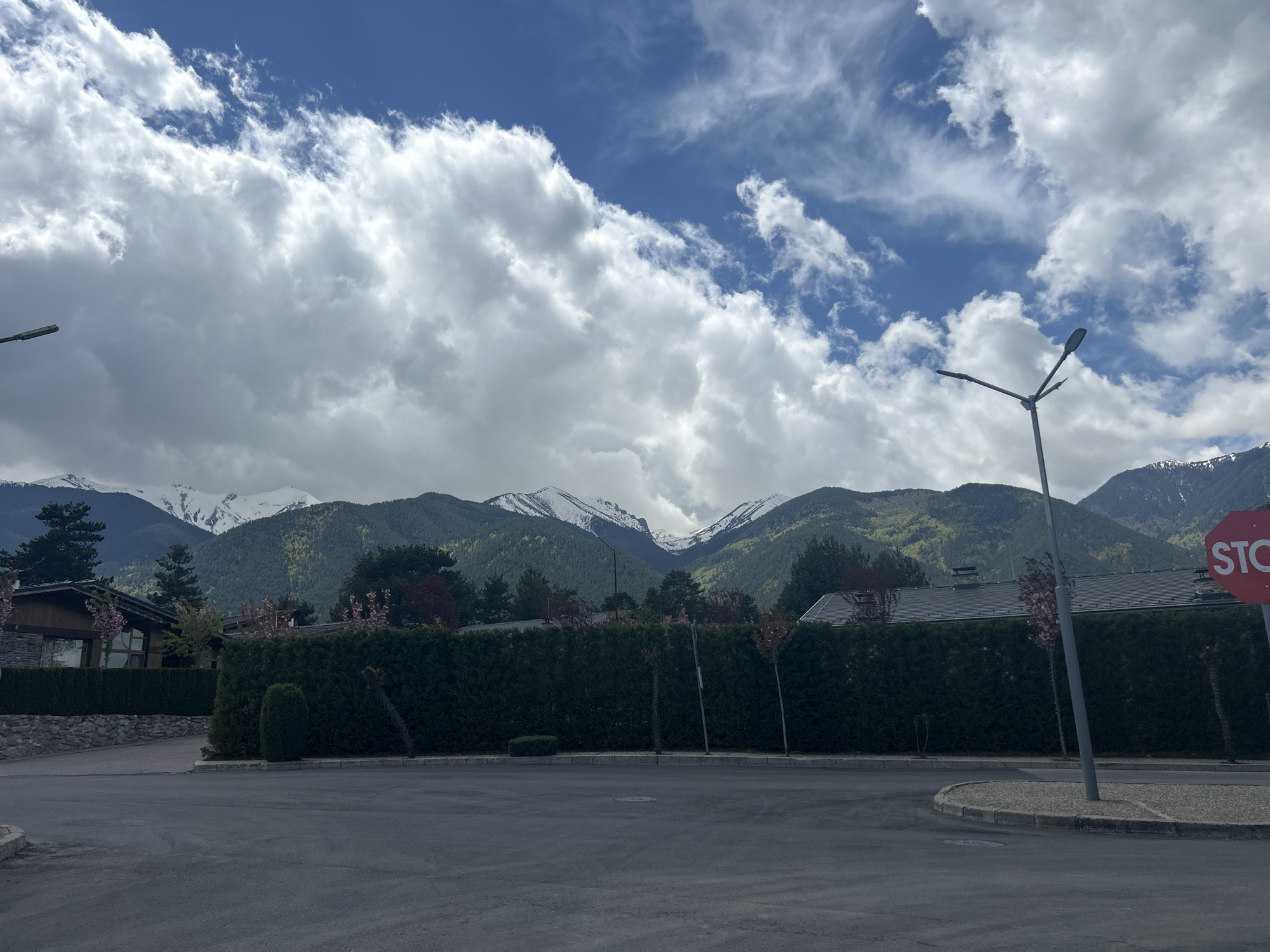 Bulgarian street scene shows snow-capped mountains under cloudy skies