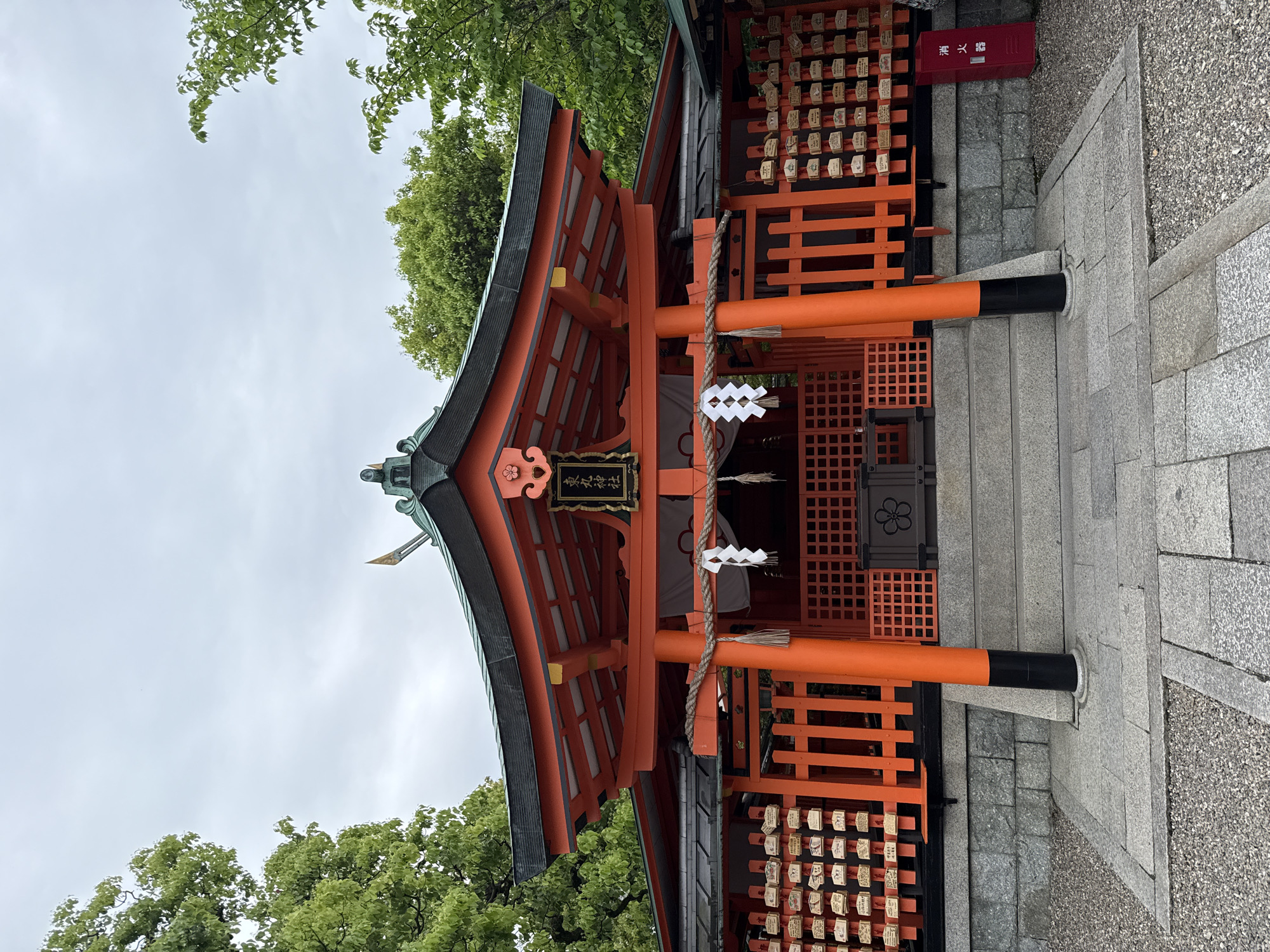 Visitor documents traditional elements of Fushimi Inari Shrine, Kyoto