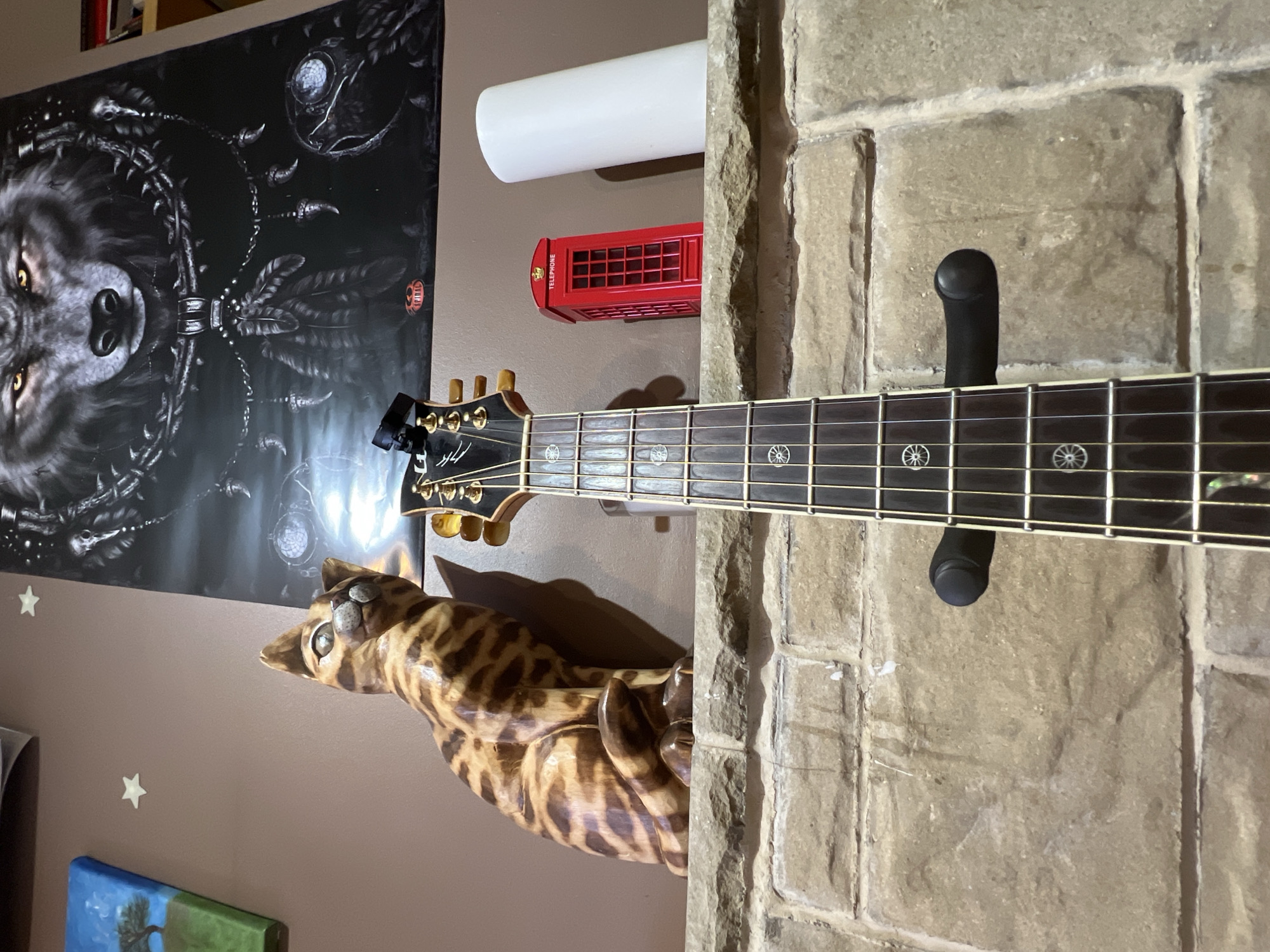 Acoustic guitar mounted on a brick fireplace at home