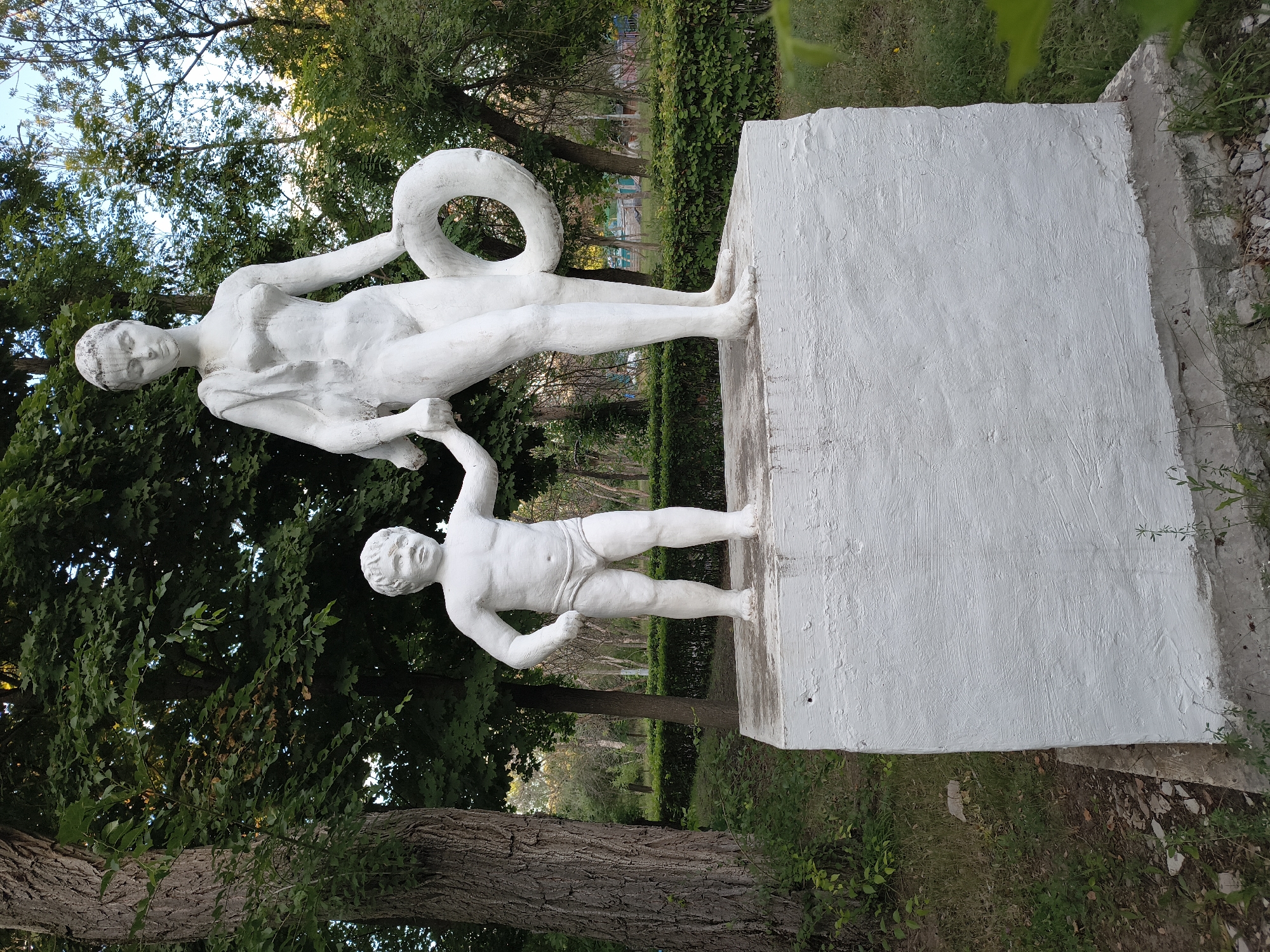 Evening at Mikhaylovka's riverside park — sculptures, beach, and promenade