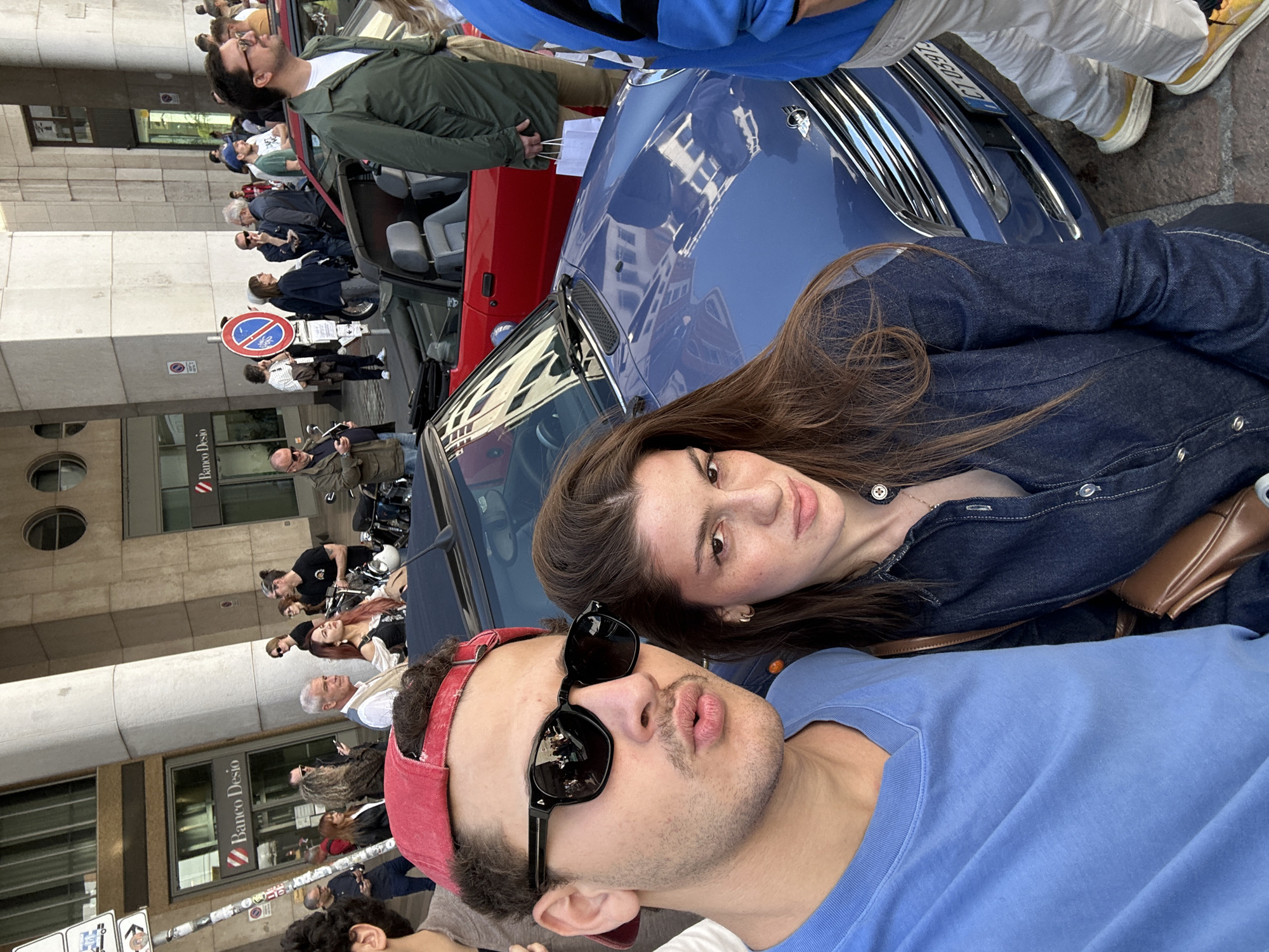 Car enthusiasts pose with vehicles in Milan streets