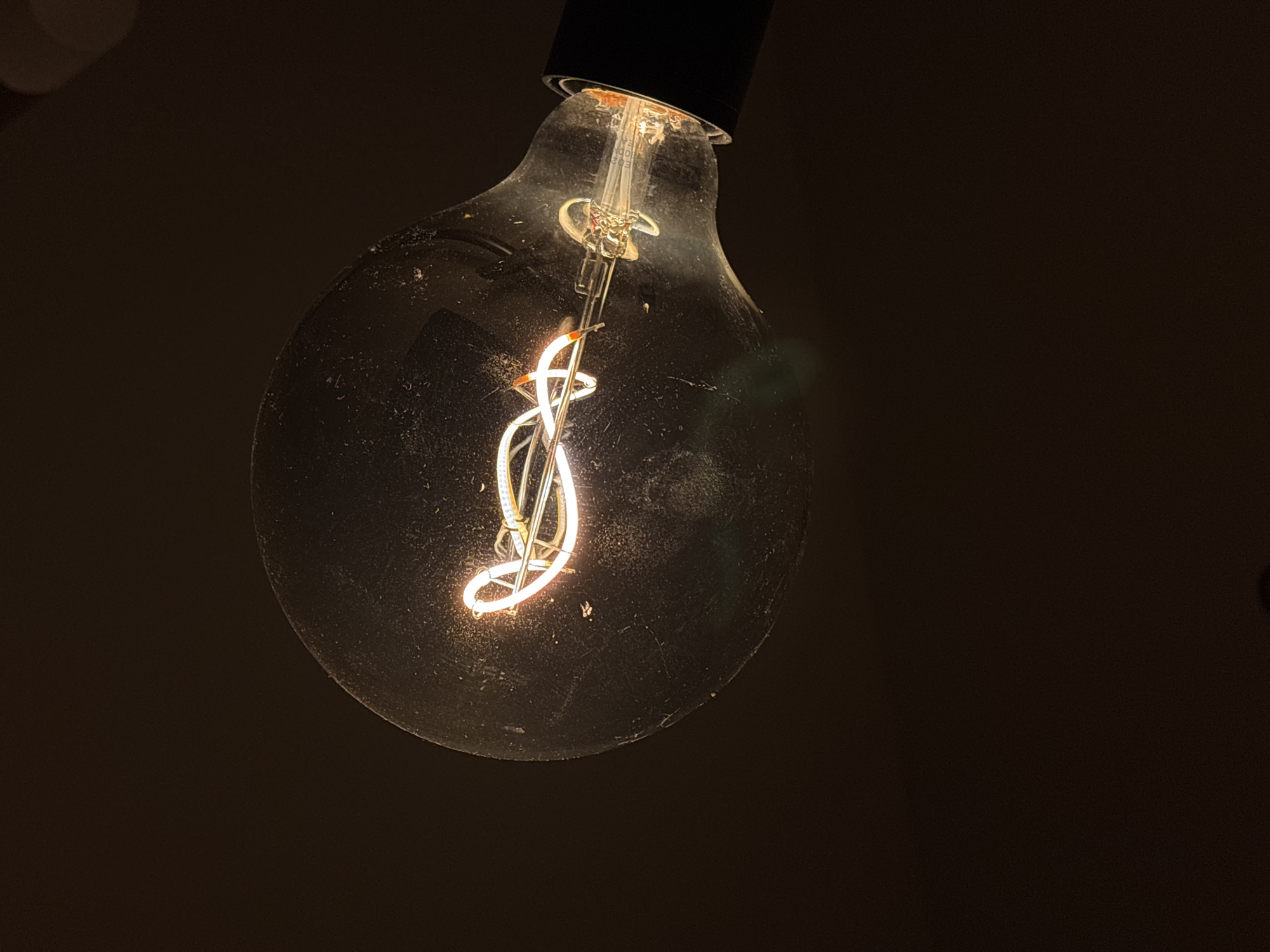 Glowing lightbulb photographed in dimly lit setting