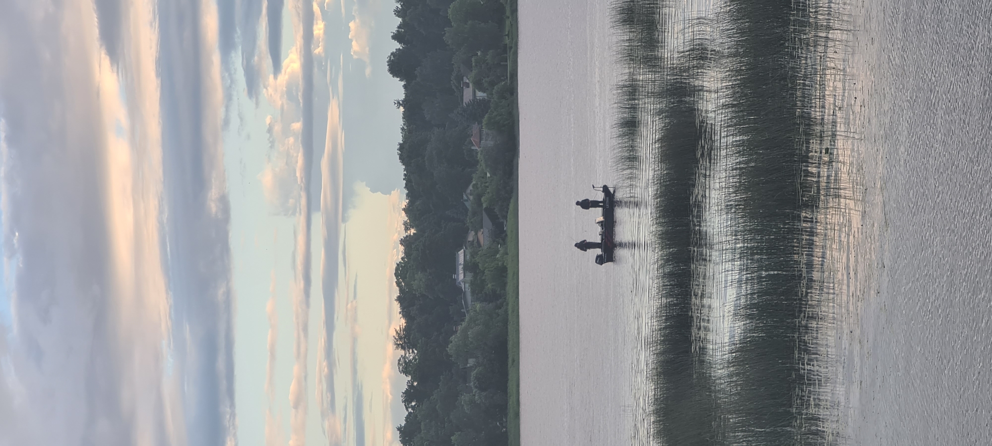 Fishing on open water near a brick-paved area in Riga