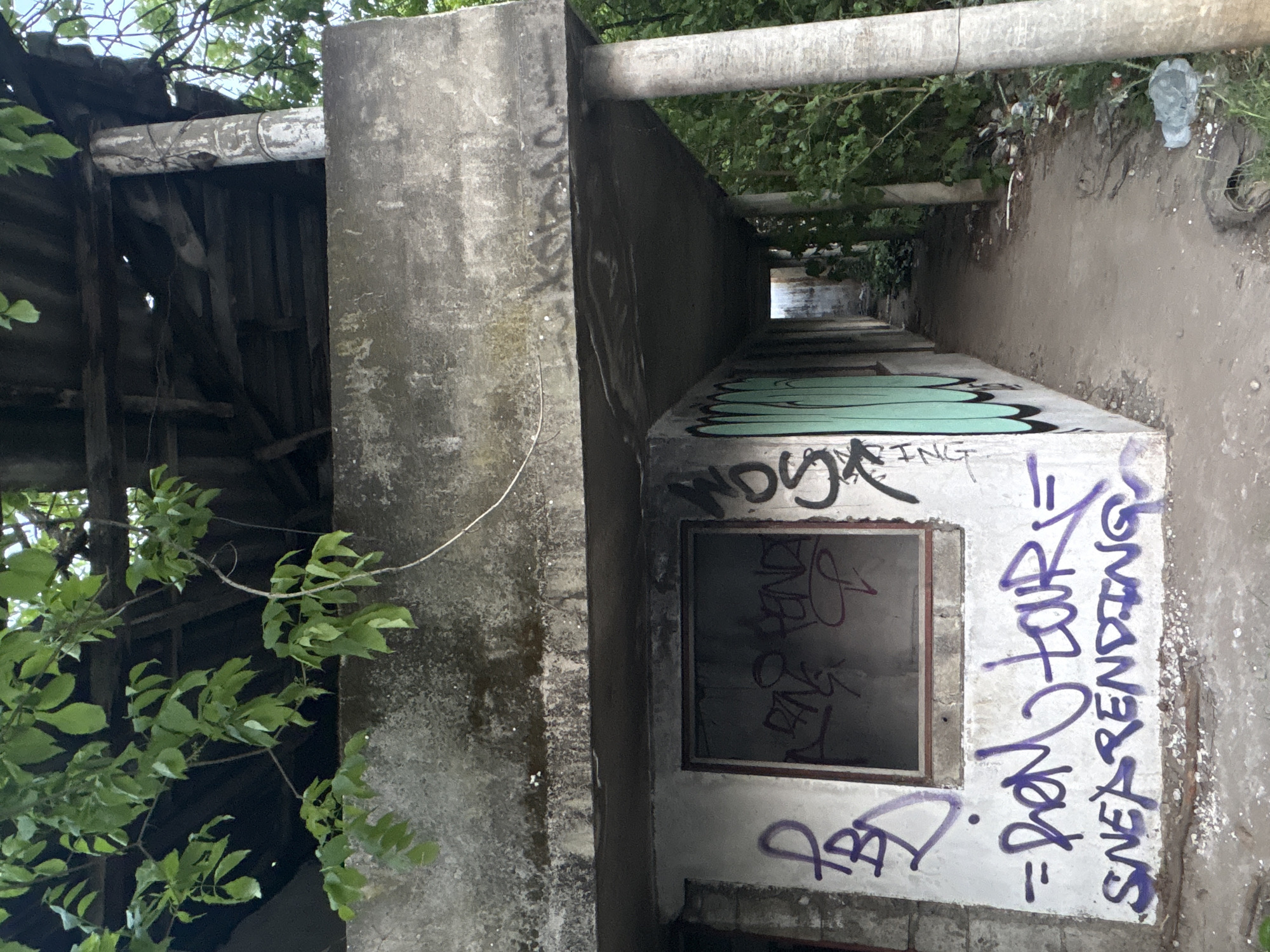 Graffiti-covered abandoned concrete structure documented in Podgorica passageway