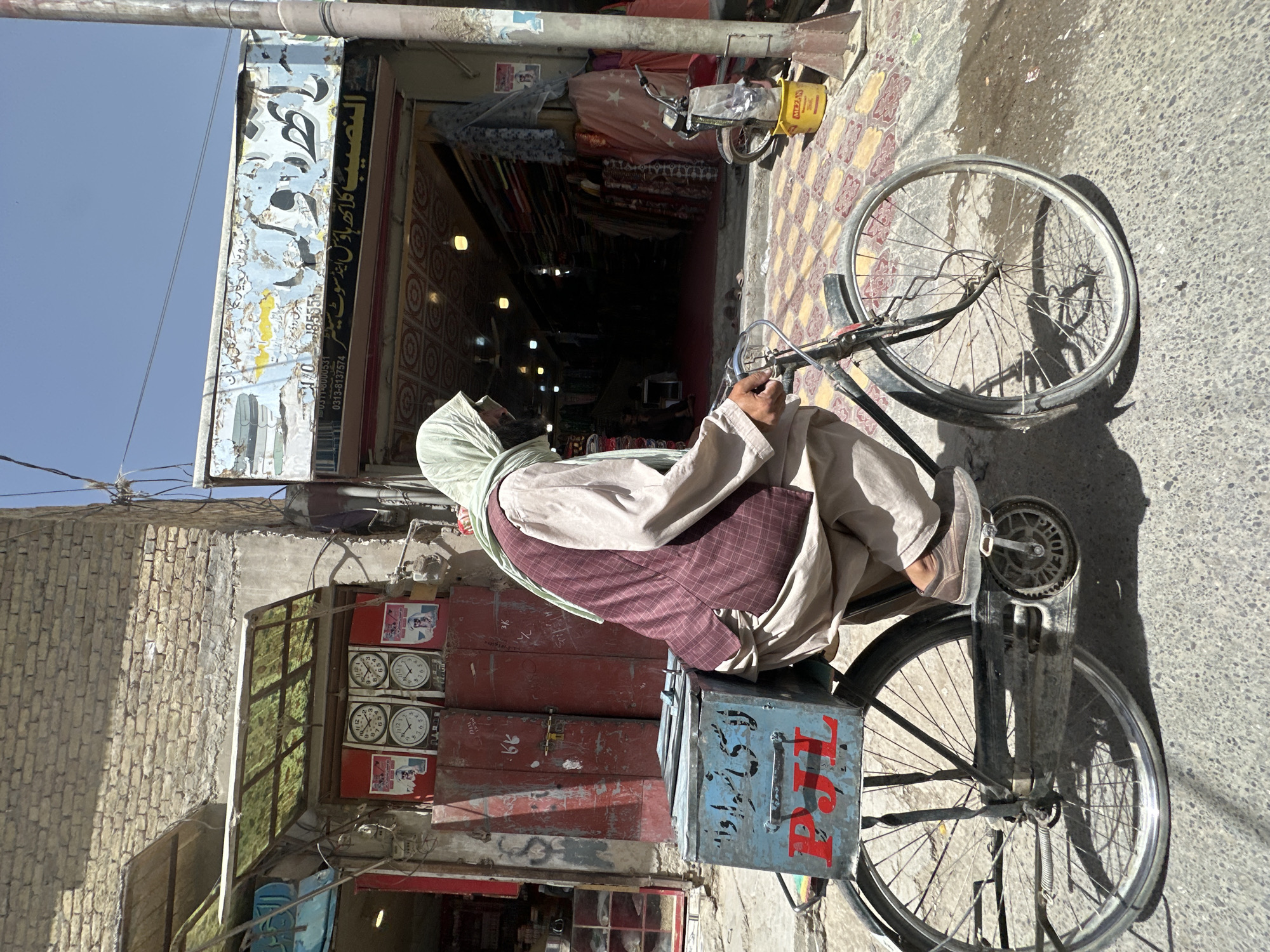 Cyclist navigates a sunny street in Quetta, Pakistan